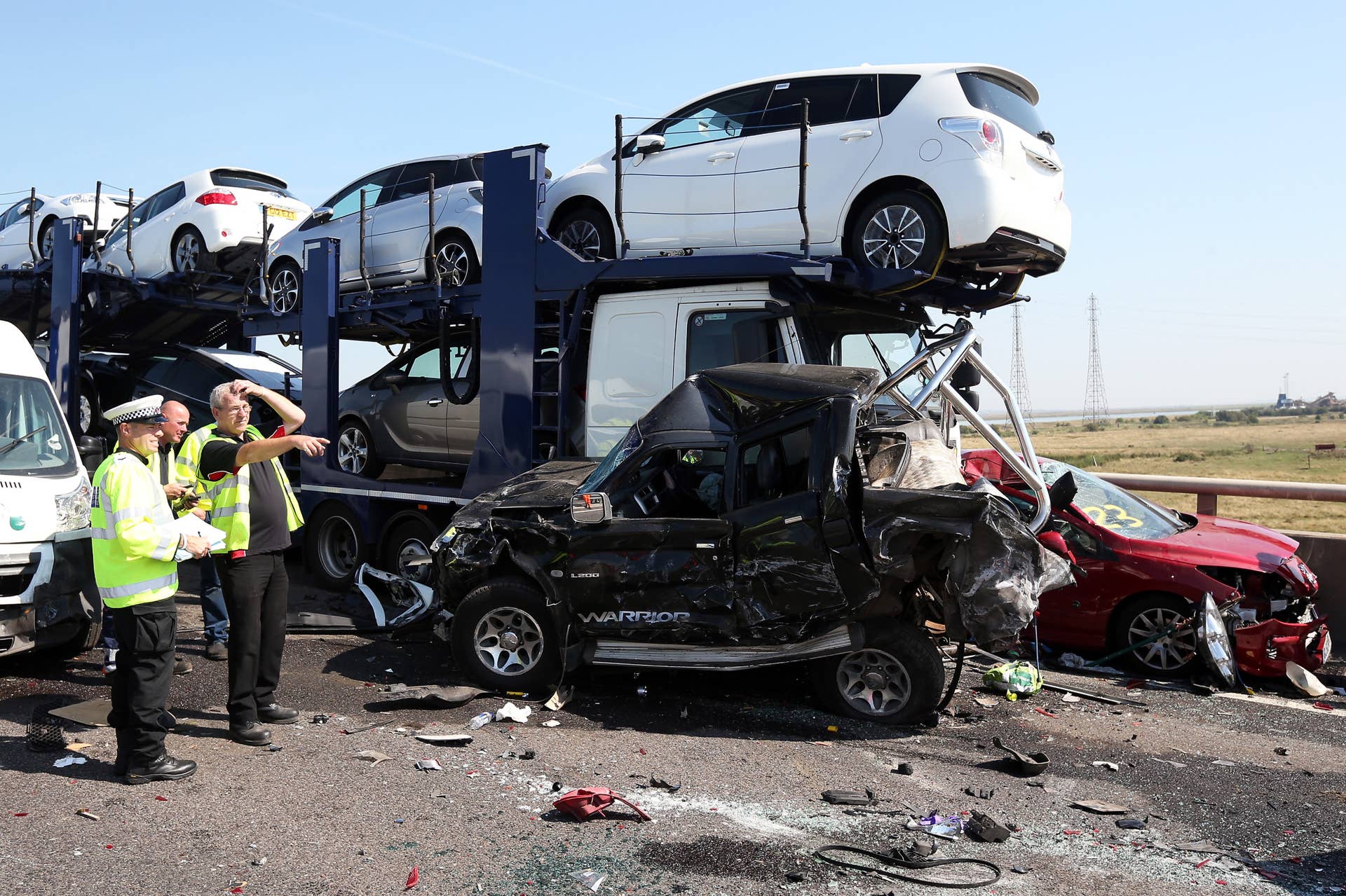 ISLE OF SHEPPEY, KENT - SEPTEMBER 05:  A vehicle recovery worker talks to a Police officer at the site of a major traffic accident on the A249 Sheppey crossing bridge in Kent on September 5, 2013 in Isle of Sheppey, Kent. Over 130 vehicles were involved in the series of accidents, with thick fog blamed for poor visibility. The crash occurred around 07:15AM BST, with at least 8 people suffering serious injuries, and approximately 60 people treated for minor injuries.  (Photo by Peter Macdiarmid/Getty Images)