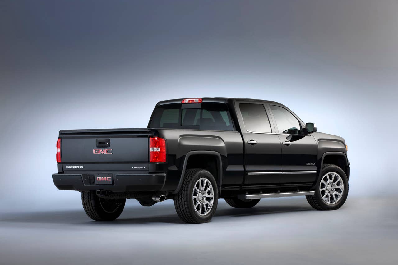 2014 GMC Sierra Denali Crew Cab in Iridium Metallic right rear three quarter shot shows body-color rear bumper, integrated Corner Step and hand grips that allow easy access to the Cargo bed.