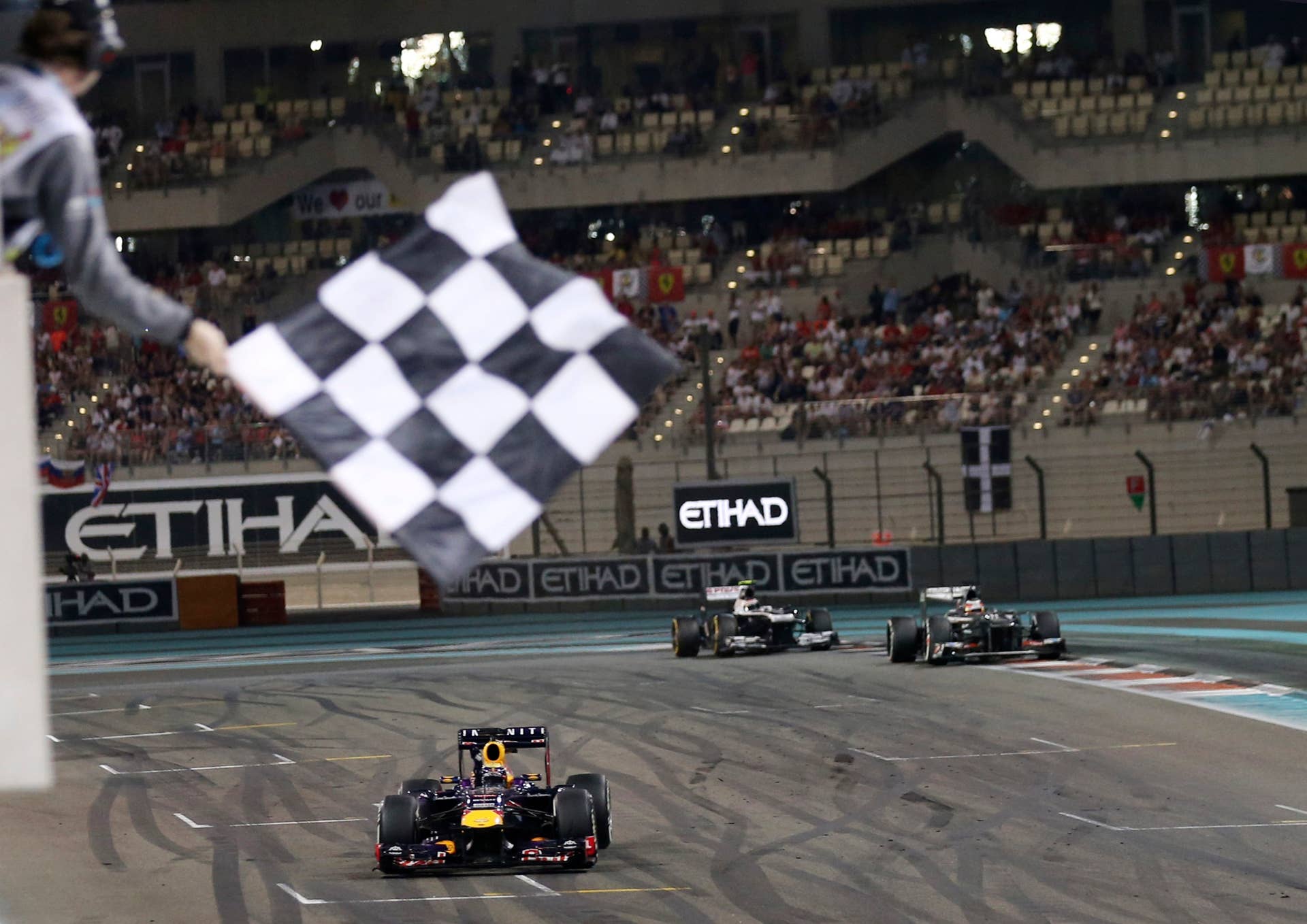 Red Bull driver Sebastian Vettel of Germany crosses the finish line to win the Abu Dhabi Formula One Grand Prix at the Yas Marina racetrack in Abu Dhabi, United Arab Emirates, Sunday, Nov. 3, 2013. (AP Photo/Luca Bruno)