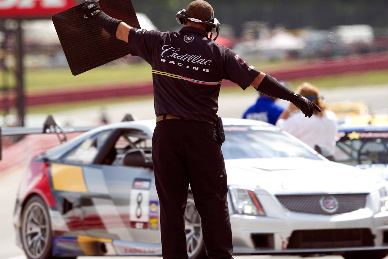 Cadillac Racing, SCCA Pro Racing World Challenge, Mid-Ohio Sports Car Course, Lexington, Ohio, August 5-7, 2011. A Cadillac Racing crew member guides Andy Pilgrim in CTS-V #8 into his pit during a practice session (Richard Prince/Cadillac Racing Photo).