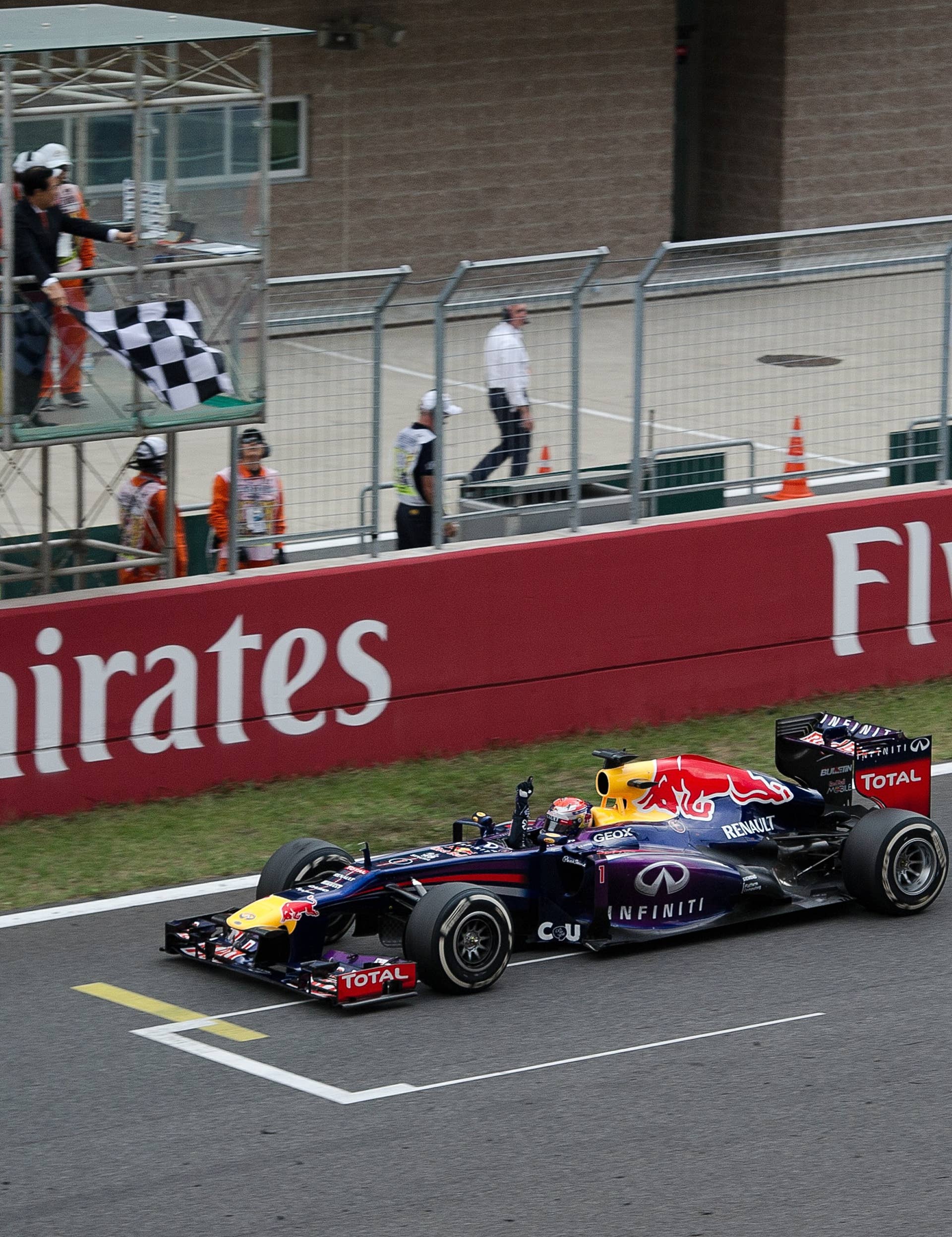 Red Bull driver Sebastian Vettel of Germany drives and celebrates after crossing the finish line, winning the Formula One Korean Grand Prix in Yeongam on October 6, 2013. AFP PHOTO/ Nicolas ASFOURI        (Photo credit should read NICOLAS ASFOURI/AFP/Getty Images)