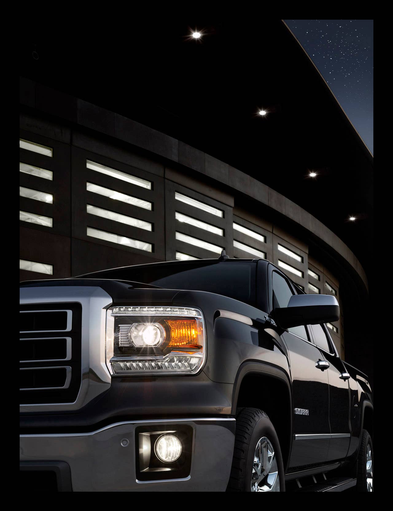 2014 GMC Sierra SLT Crew Cab headlamp detail shot shows the projecter beam headlamps, signature LED lights and foglamps.