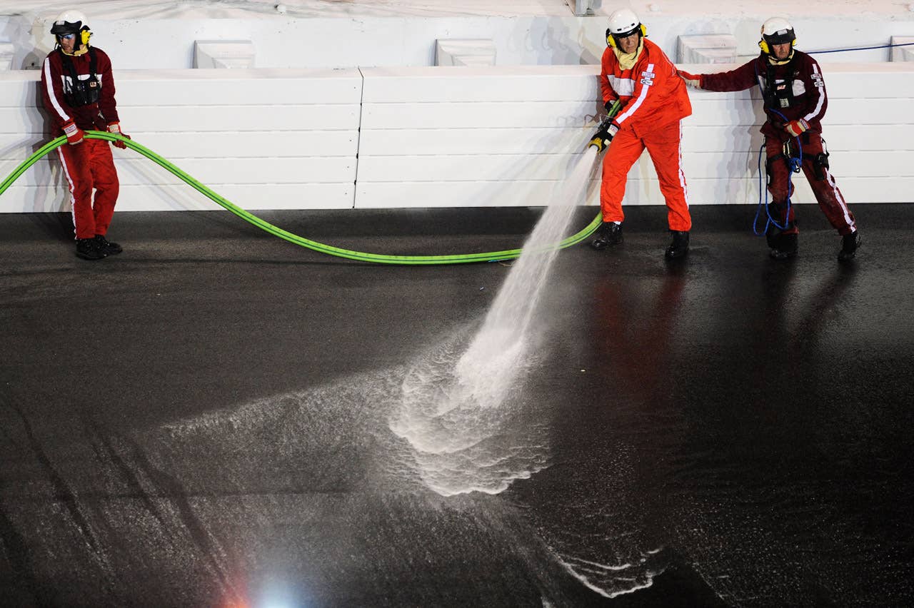 DAYTONA BEACH, FL - FEBRUARY 27:  Safety workers clean up the track after a jet dryer burst into flames after being hit under caution by Juan Pablo Montoya, driver of the #42 Target Chevrolet, during the NASCAR Sprint Cup Series Daytona 500 at Daytona International Speedway on February 27, 2012 in Daytona Beach, Florida.  (Photo by John Harrelson/Getty Images for NASCAR)