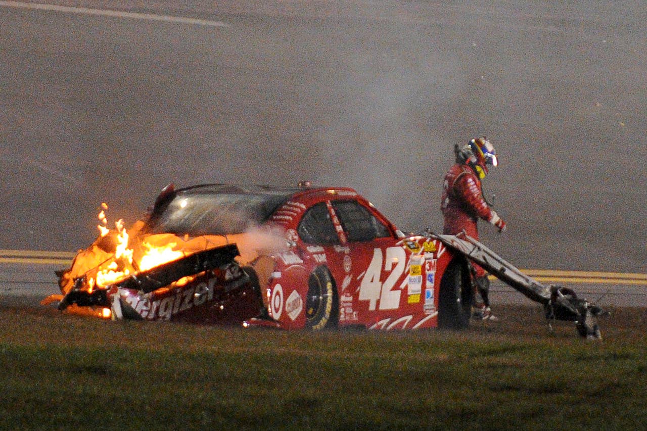 Juan Pablo Montoya, of Colombia, walks from his car after it collided with a track-drying truck during the NASCAR Daytona 500 auto race at Daytona International Speedway in Daytona Beach, Fla., Monday, Feb. 27, 2012. (AP Photo/Rob Sweeten)
