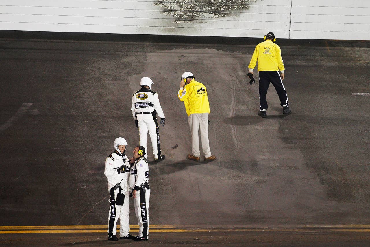DAYTONA BEACH, FL - FEBRUARY 27:  NASCAR Officials inspect the track after a jet dryer burst into flames after Juan Pablo Montoya, driver of the #42 Target Chevrolet,  hit the dryer under caution during the NASCAR Sprint Cup Series Daytona 500 at Daytona International Speedway on February 27, 2012 in Daytona Beach, Florida.  (Photo by Chris Graythen/Getty Images)