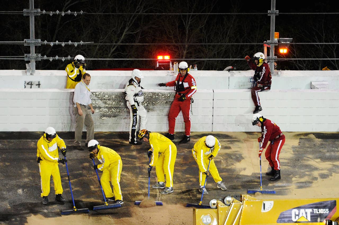DAYTONA BEACH, FL - FEBRUARY 27:  Crews inspect the track as safety workers clean up after a jet dryer burst into flames after being hit under caution by Juan Pablo Montoya, driver of the #42 Target Chevrolet, during the NASCAR Sprint Cup Series Daytona 500 at Daytona International Speedway on February 27, 2012 in Daytona Beach, Florida.  (Photo by John Harrelson/Getty Images for NASCAR)