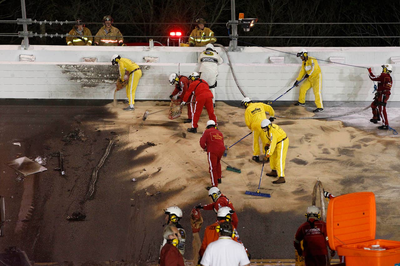 Workers repair damage after a jet dryer burned after Juan Pablo Montoya's car collided with the dryer during the NASCAR Daytona 500 auto race in Daytona Beach, Fla., Monday, Feb. 27, 2012. (AP Photo/Michael L. Levitt)