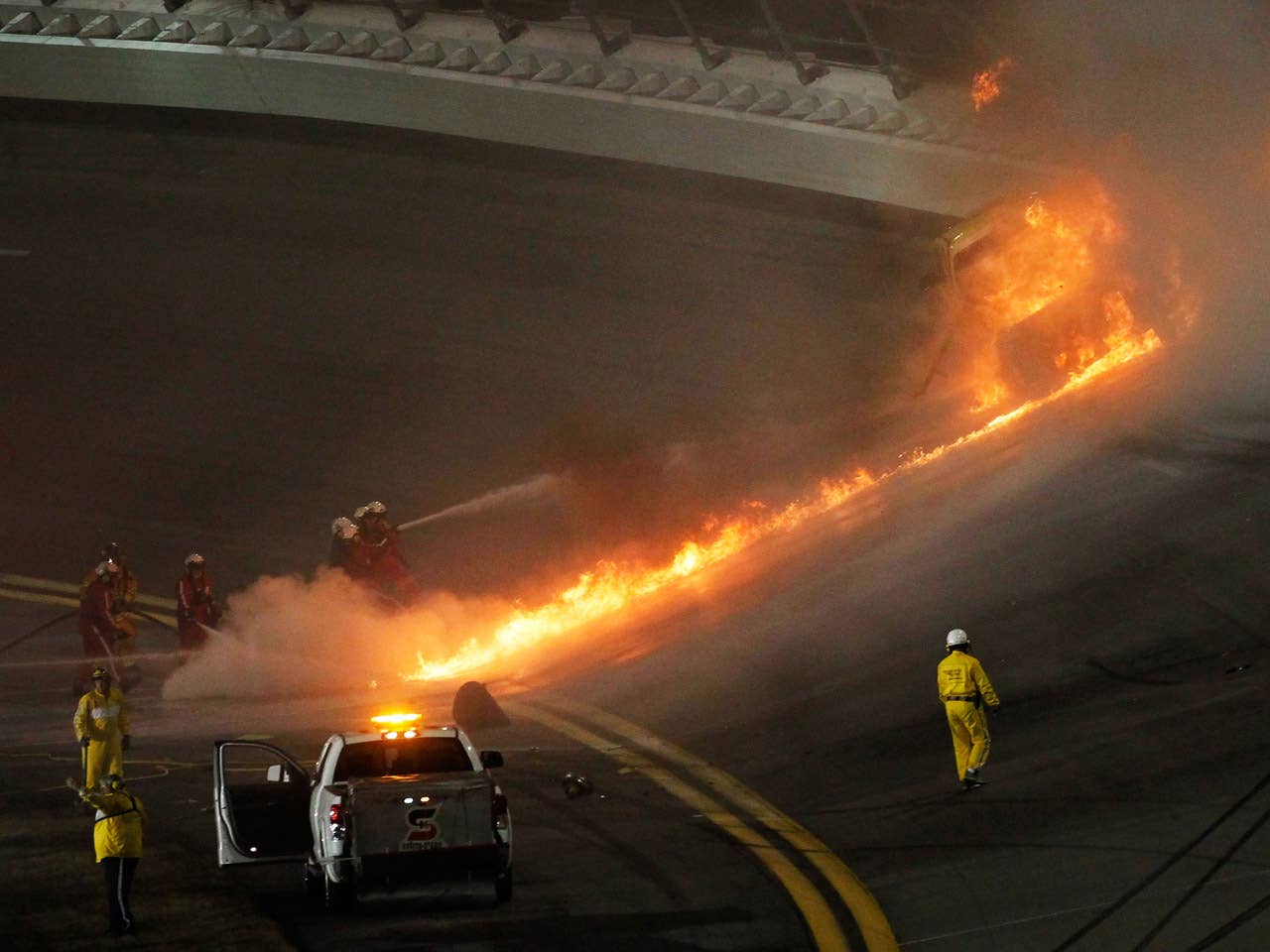 DAYTONA BEACH, FL - FEBRUARY 27:  Safety workers try to extinguish a fire from a jet dryer after being hit by Juan Pablo Montoya, driver of the #42 Target Chevrolet, under caution during the NASCAR Sprint Cup Series Daytona 500 at Daytona International Speedway on February 27, 2012 in Daytona Beach, Florida.  (Photo by Jonathan Ferrey/Getty Images for NASCAR)