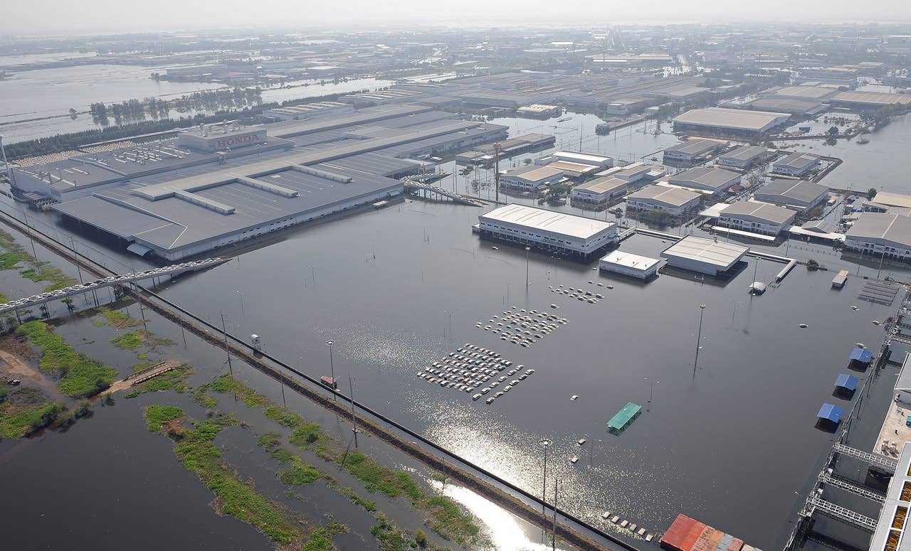 TO GO WITH 'THAILAND-FLOODS-ECONOMY-BUSINESS' by Kelly Macnamara (FILES) This aerial picture shows cars submerged in floodwaters at a Honda automotive factory at an industrial estate in Ayutthaya province on November 19, 2011.  Huge swathes of central Thailand were left under water for weeks when severe monsoon rains caused massive inundations, ruining crops, closing thousands of factories and swamping millions of homes. Hundreds of thousands of people were put out of work when the floodwaters swept into key industrial estates in Ayutthaya and on the outskirts of the capital Bangkok.    AFP PHOTO / Pornchai KITTIWONGSAKUL (Photo credit should read PORNCHAI KITTIWONGSAKUL/AFP/Getty Images)