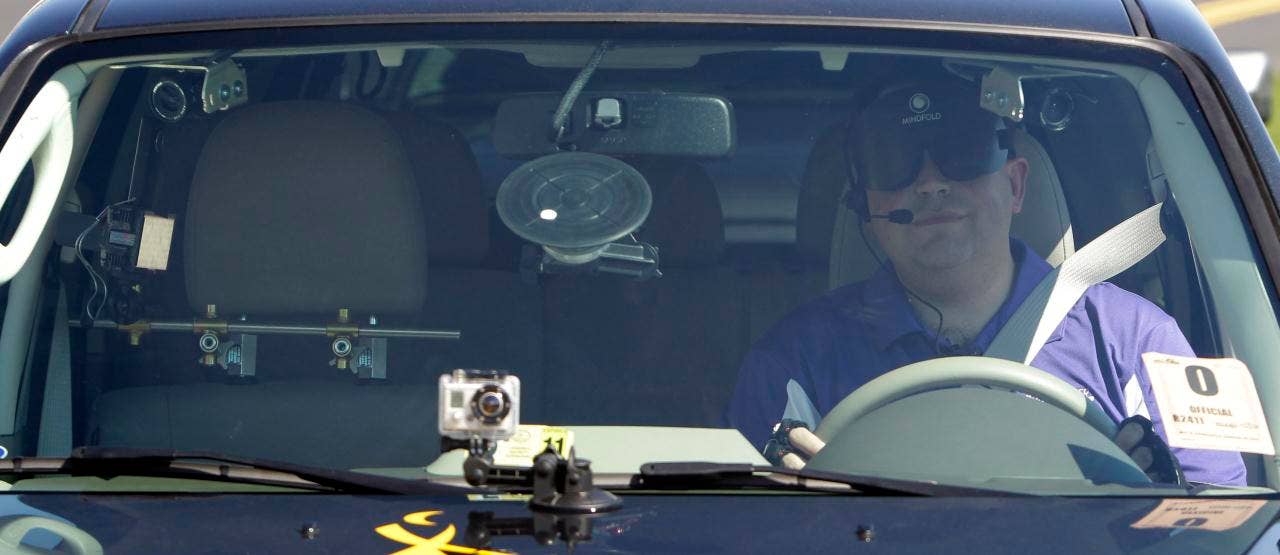 Blind driver Mark Riccobono sits behind the wheel of a specially modified car before driving around the road course in a demonstration at Daytona International Speedway in Daytona Beach, Fla., Saturday, Jan. 29, 2011.(AP Photo/John Raoux)