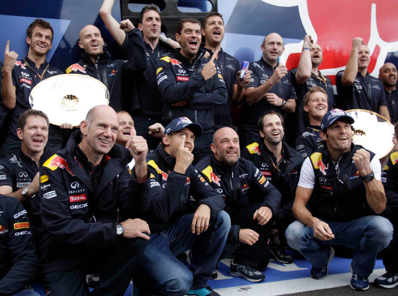 Red Bull driver Sebastian Vettel of Germany, center, and teammate Mark Webber from Australia, right, celebrate with the team, after the Belgian Formula One Grand Prix in Spa-Francorchamps, Sunday, Aug. 28, 2011. Red Bull driver Sebastian Vettel of Germany won the race, Red Bull driver Mark Webber of Australia placed second, and McLaren Mercedes driver Jenson Button of Britain placed third. (AP Photo/Frank Augstein)