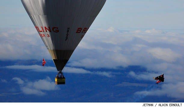 Jetman Yves Rossy flys his jetwing out of a hot air balloon.