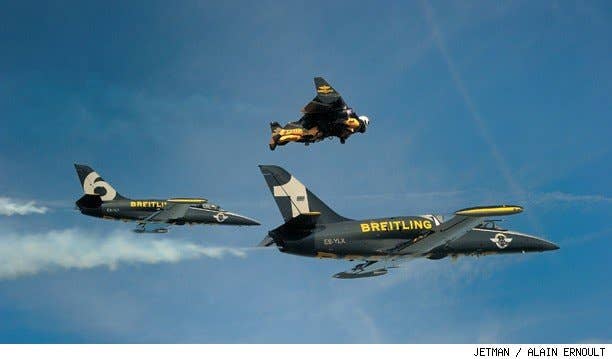 Jetman Yves Rossy flys his jetwing in formation with other aircraft.