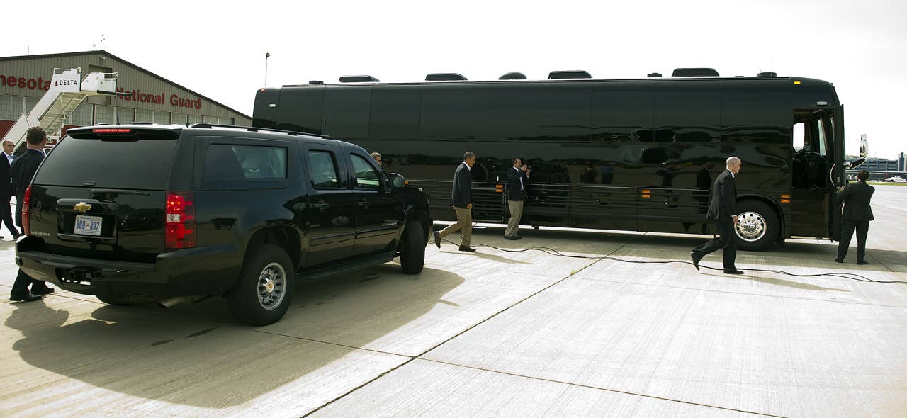 US President Barack Obama (C) walks to his bus as he arrives in Minneapolis-St. Paul International Airport, Minnesota, August 15, 2011, where he is to begin his three-day bus tour in the Midwest centering on ways to grow the economy.          AFP PHOTO/Jim WATSON (Photo credit should read JIM WATSON/AFP/Getty Images)