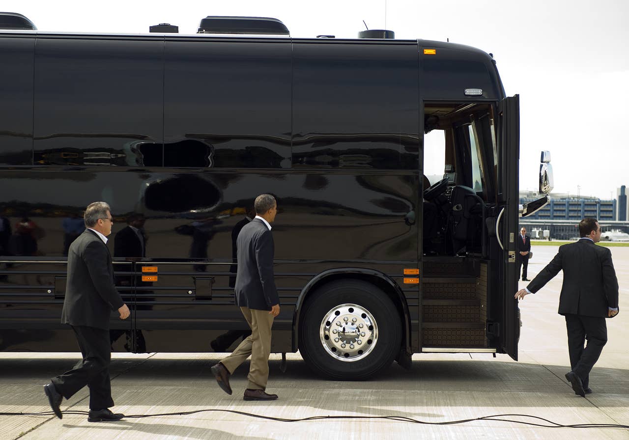 US President Barack Obama (C) walks to his bus as he arrives in Minneapolis-St. Paul International Airport, Minnesota, August 15, 2011, where he is to begin his three-day bus tour in the Midwest centering on ways to grow the economy.          AFP PHOTO/Jim WATSON (Photo credit should read JIM WATSON/AFP/Getty Images)