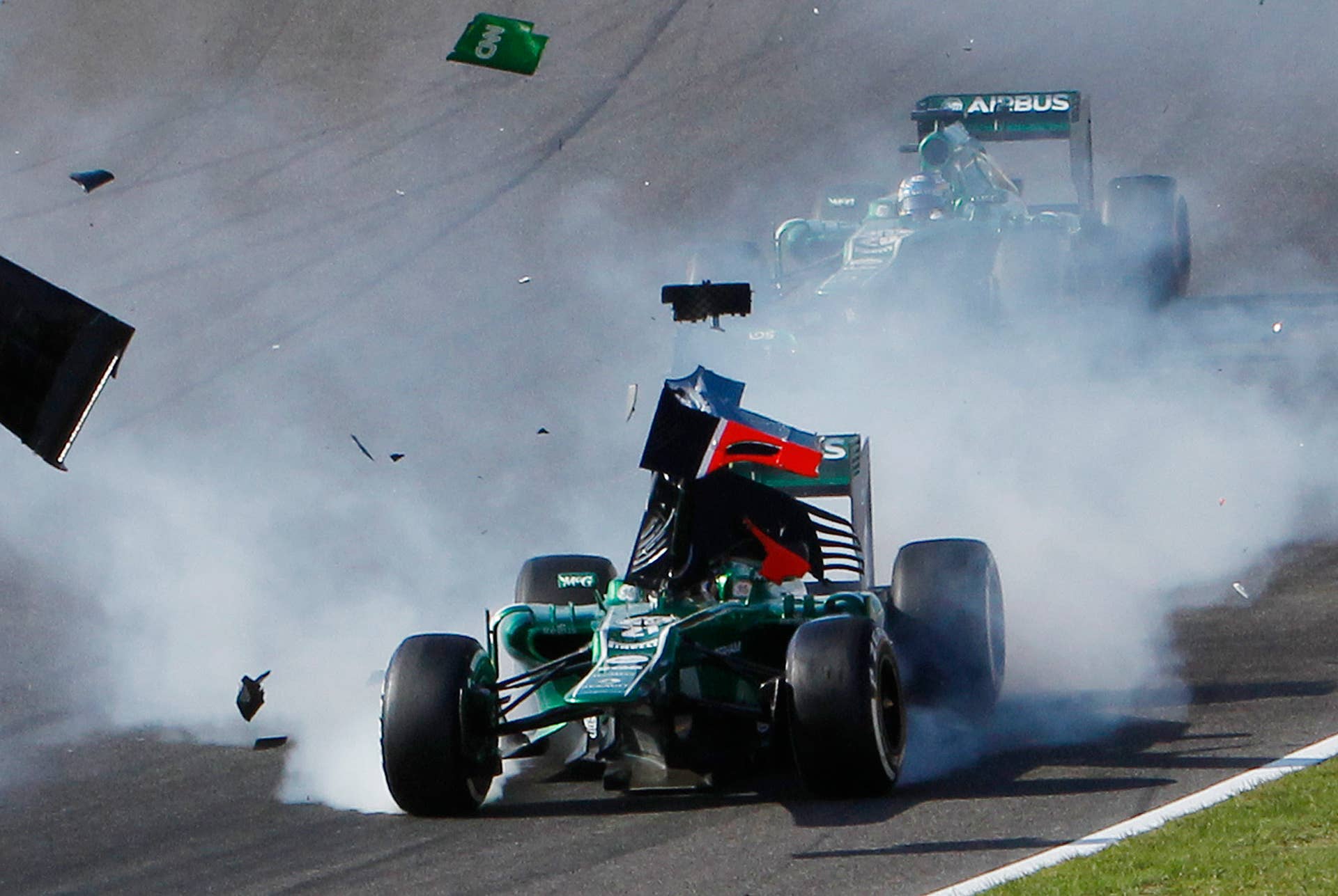 The wing of Marussia driver Jules Bianchi flies across the car of Caterham driver Giedo van der Garde of the Netherlands, after they collided at the start of the Japanese Formula One Grand Prix at the Suzuka circuit in Suzuka, Japan, Sunday, Oct. 13, 2013. (AP Photo/Shuji Kajiyama)