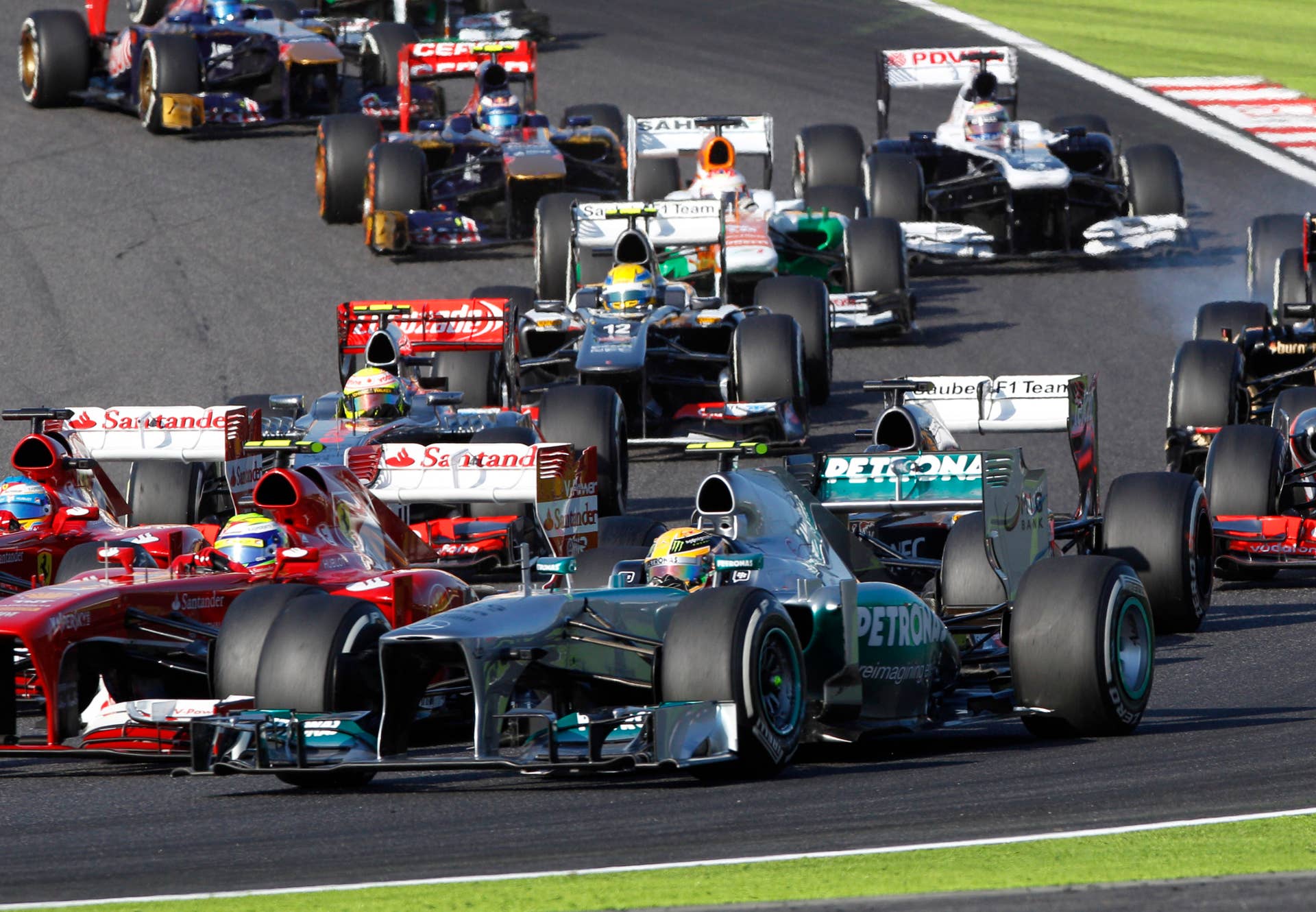 Mercedes driver Lewis Hamilton of Britain, foreground, steers his car through turn 2 at the start of the Japanese Formula One Grand Prix at the Suzuka circuit in Suzuka, Japan, Sunday, Oct. 13, 2013. (AP Photo/Greg Baker)