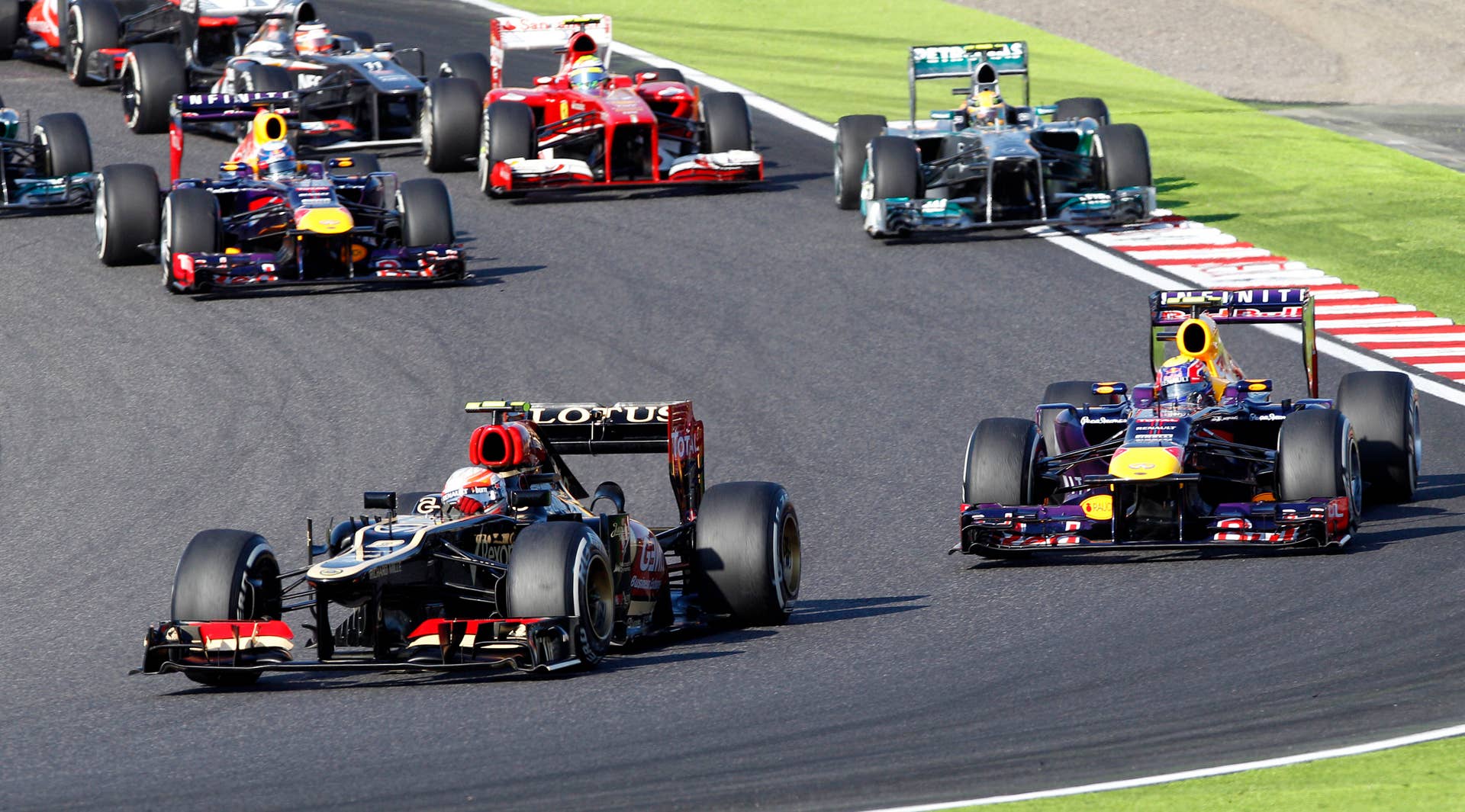 Lotus driver Romain Grosjean of France, left, leads Red Bull driver Mark Webber of Australia into turn 2 at the start of the Japanese Formula One Grand Prix at the Suzuka circuit in Suzuka, Japan, Sunday, Oct. 13, 2013. (AP Photo/Greg Baker)