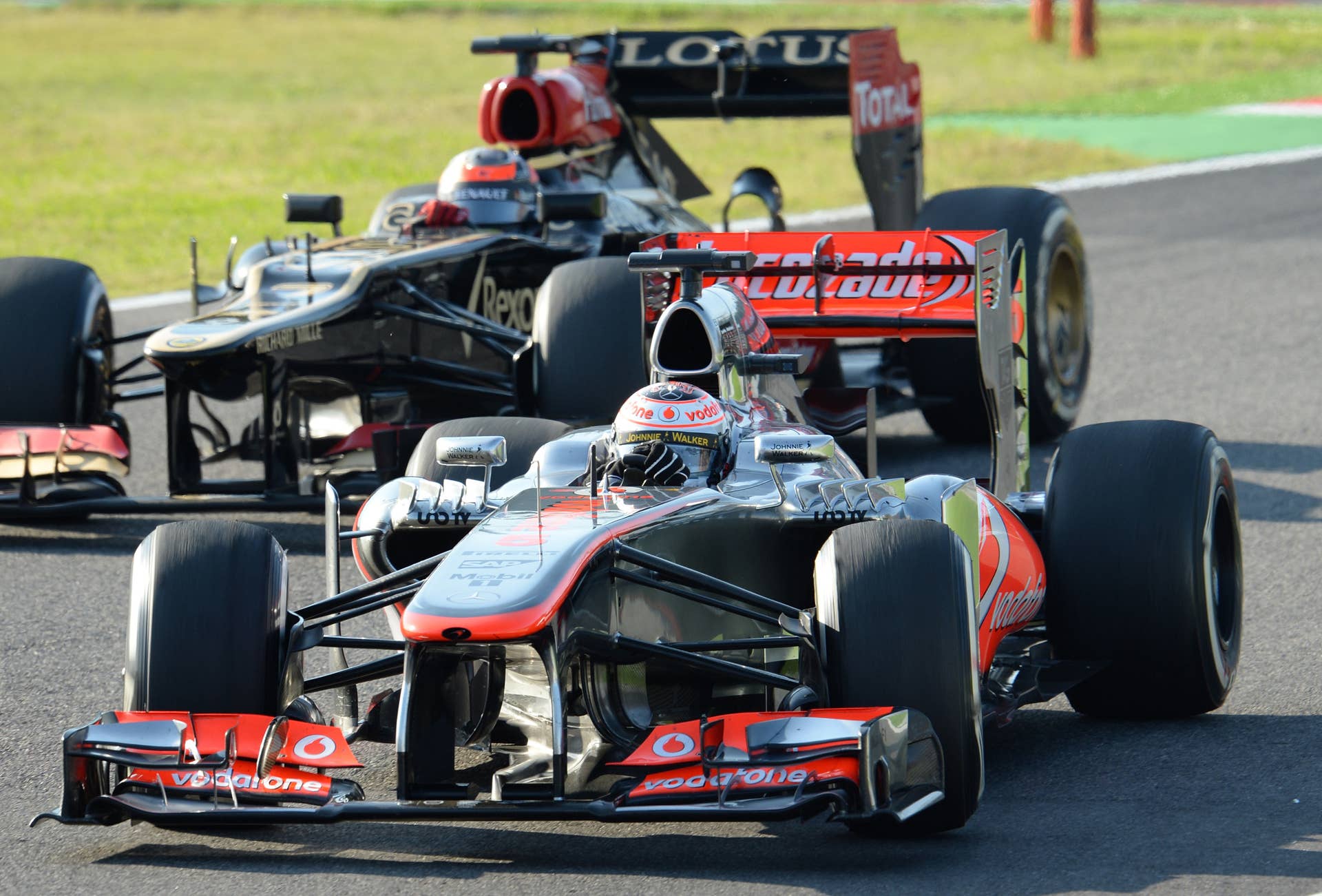 McLaren driver Jenson Button of Britain (front) leads Lotus driver Kimi Raikkonen of Finland during the Formula One Japanese Grand Prix in Suzuka on October 13, 2013.       AFP PHOTO/Toru YAMANAKA        (Photo credit should read TORU YAMANAKA/AFP/Getty Images)