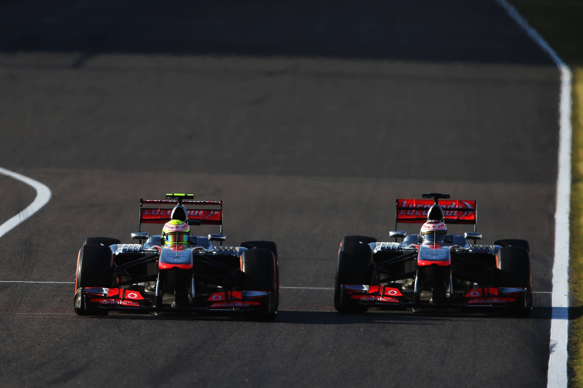 SUZUKA, JAPAN - OCTOBER 13:  (L-R) Sergio Perez of Mexico and McLaren and Jenson Button of Great Britain and McLaren drive side by side towards first corner during the Japanese Formula One Grand Prix at Suzuka Circuit on October 13, 2013 in Suzuka, Japan.  (Photo by Mark Thompson/Getty Images)