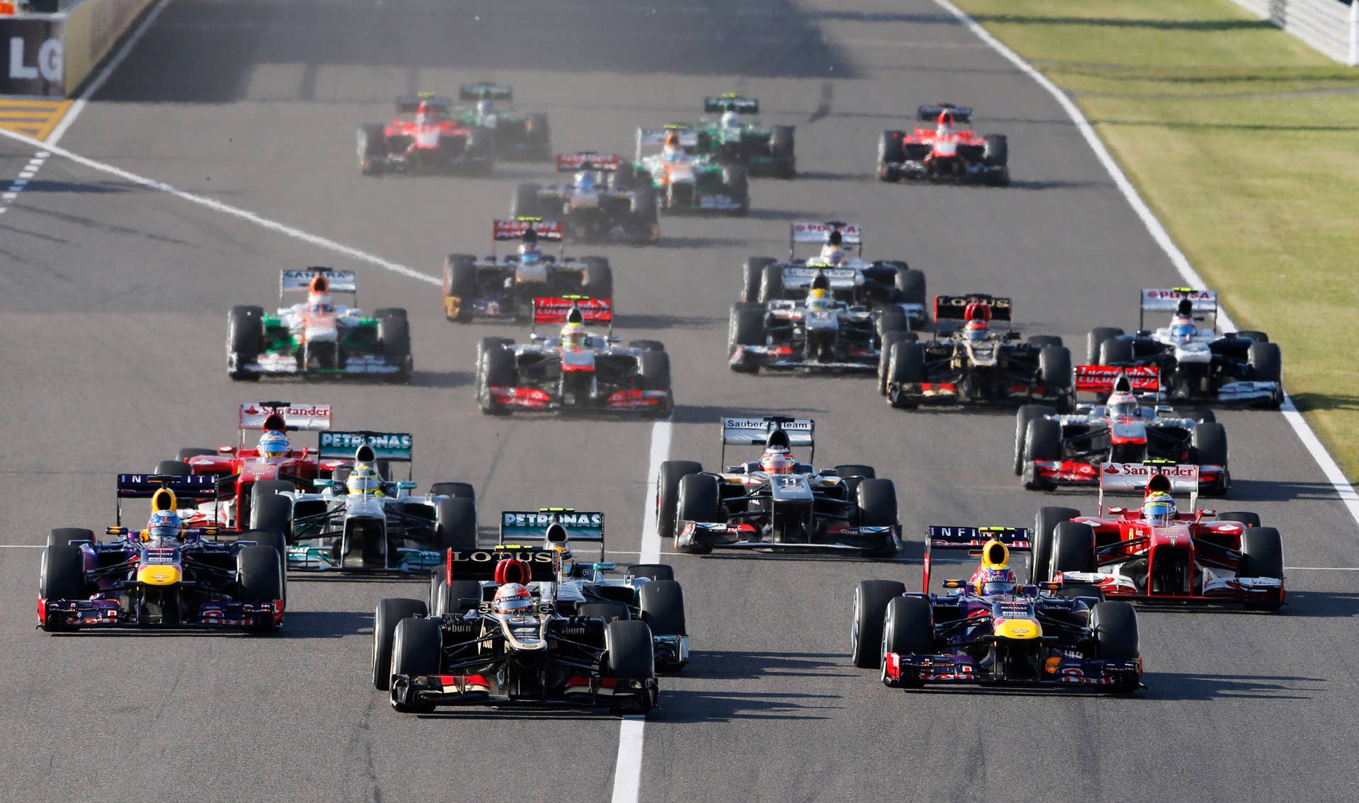 Lotus driver Romain Grosjean of France, center, leads Red Bull driver Mark Webber of Australia, front right, and Red Bull driver Sebastian Vettel of Germany, left, at the start of the Japanese Formula One Grand Prix at the Suzuka circuit in Suzuka, Japan, Sunday, Oct. 13, 2013. (AP Photo/Shuji Kajiyama)