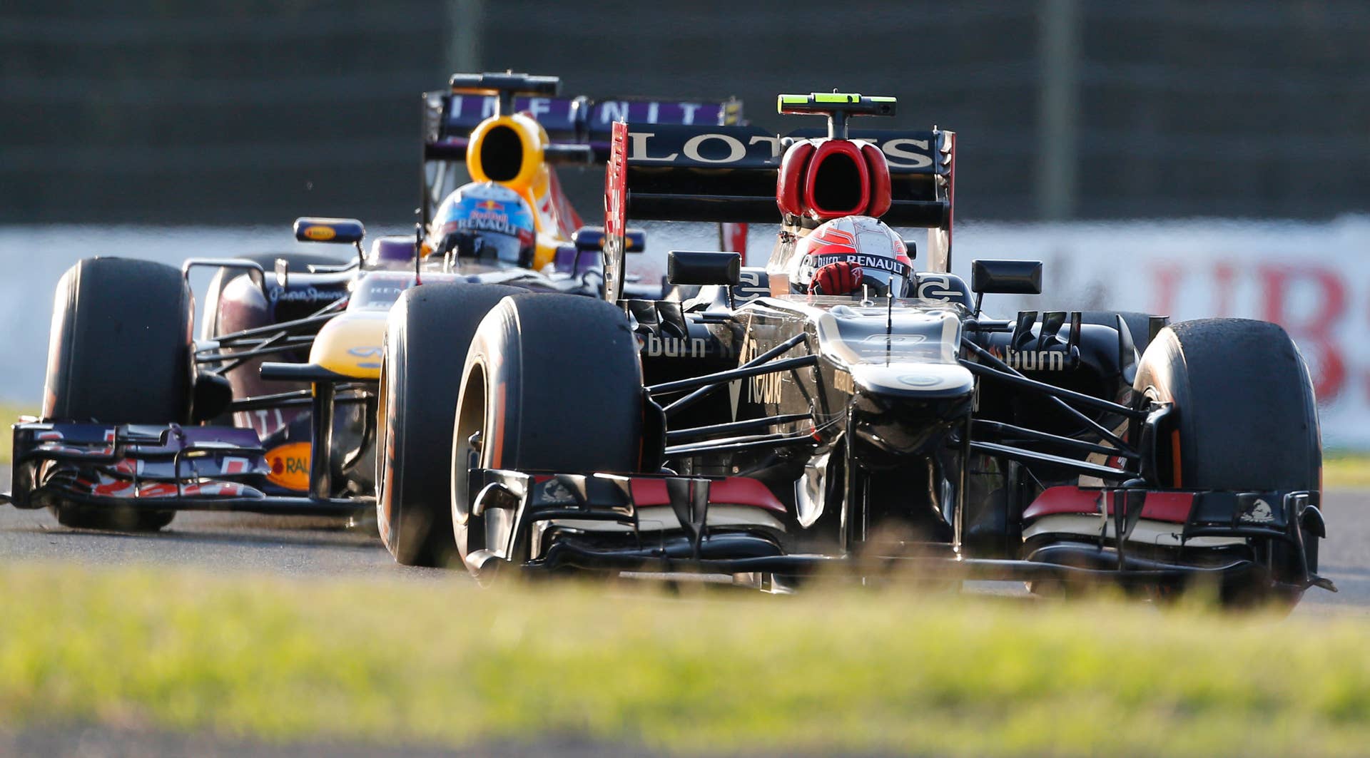 Lotus driver Romain Grosjean of France, right, and Red Bull driver Sebastian Vettel of Germany compete during the Japanese Formula One Grand Prix at the Suzuka circuit in Suzuka, Japan, Sunday, Oct. 13, 2013.(AP Photo/Koji Sasahara)