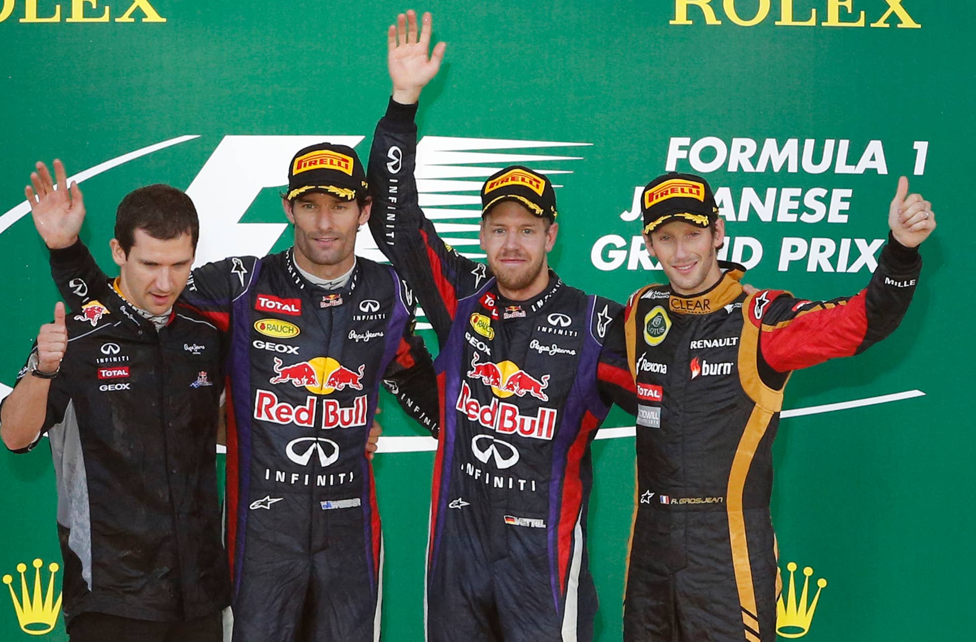 Red Bull driver Sebastian Vettel of Germany, second right,  celebrates along with second placed teammate  driver Mark Webber of Australia, second left,  and third placed Lotus driver Romain Grosjean of Franc right, on the podium after winning the Japanese Formula One Grand Prix at the Suzuka circuit in Suzuka, Japan, Sunday, Oct.13, 2013.  (AP Photo/Shuji Kajiyama)