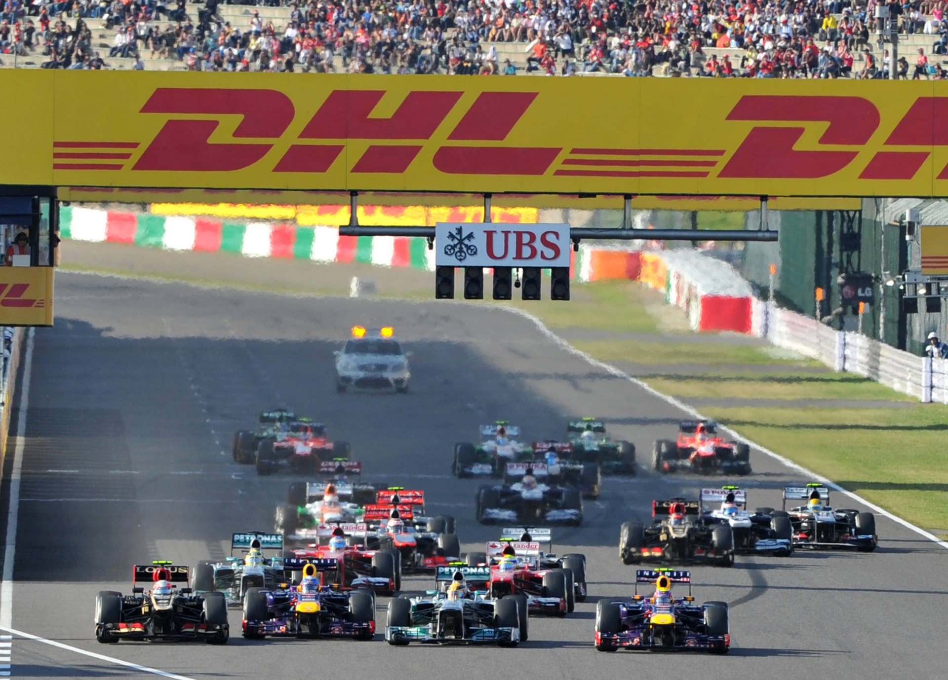 Red Bull driver Mark Webber of Australia (front R) leads the pack after the satrt of the Formula One Japanese Grand Prix in Suzuka on October 13, 2013.   AFP PHOTO / KAZUHIRO NOGI        (Photo credit should read KAZUHIRO NOGI/AFP/Getty Images)
