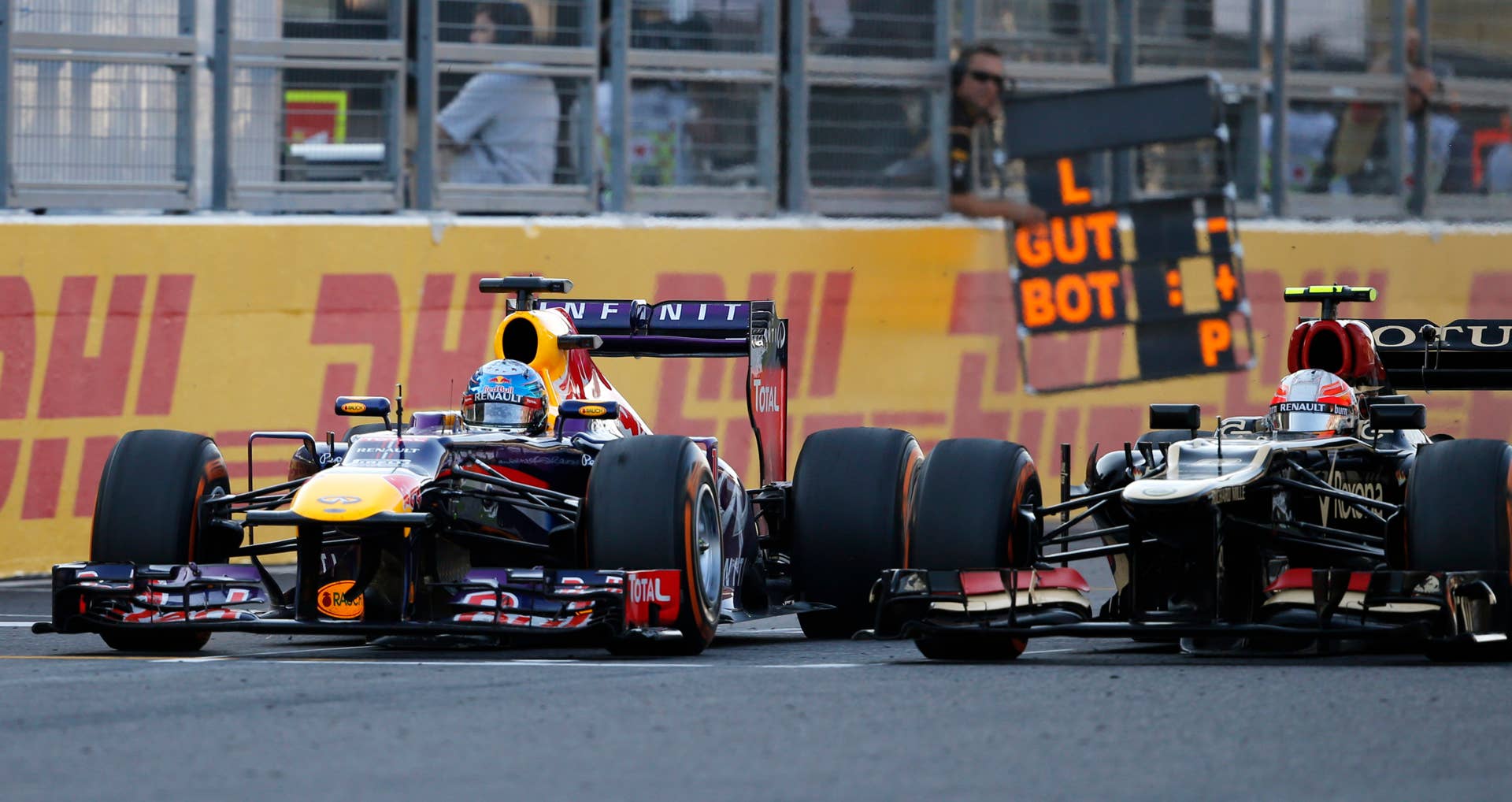 Red Bull driver Sebastian Vettel of Germany, left, and Lotus driver Romain Grosjean of France race side by side during the Japanese Formula One Grand Prix at the Suzuka circuit in Suzuka, Japan, Sunday, Oct.13, 2013. Vettel won the race and Grosjean third. (AP Photo/Shuji Kajiyama)