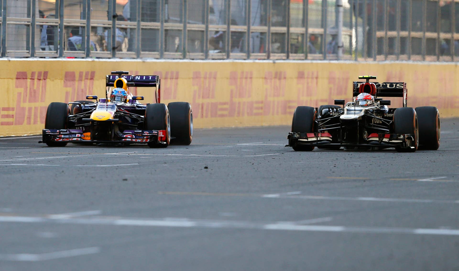Red Bull driver Sebastian Vettel of Germany, left, and Lotus driver Romain Grosjean of France race side by side during the Japanese Formula One Grand Prix at the Suzuka circuit in Suzuka, Japan, Sunday, Oct.13, 2013. Vettel won the race and Grosjean third. (AP Photo/Shuji Kajiyama)