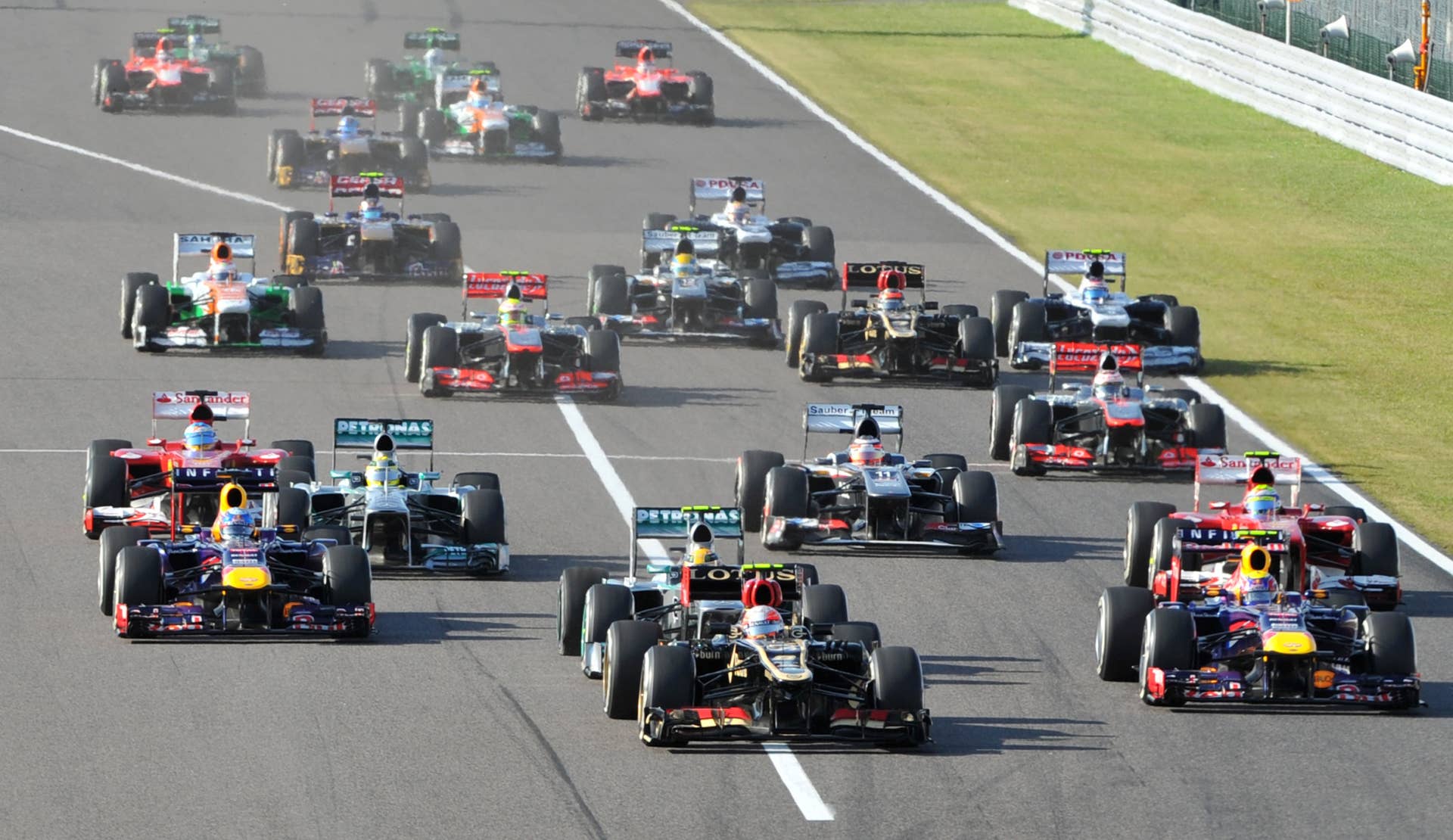 Lotus driver Romain Grosjean of France (front C) leads the pack after the satrt of the Formula One Japanese Grand Prix in Suzuka on October 13, 2013.  AFP PHOTO / KAZUHIRO NOGI        (Photo credit should read KAZUHIRO NOGI/AFP/Getty Images)