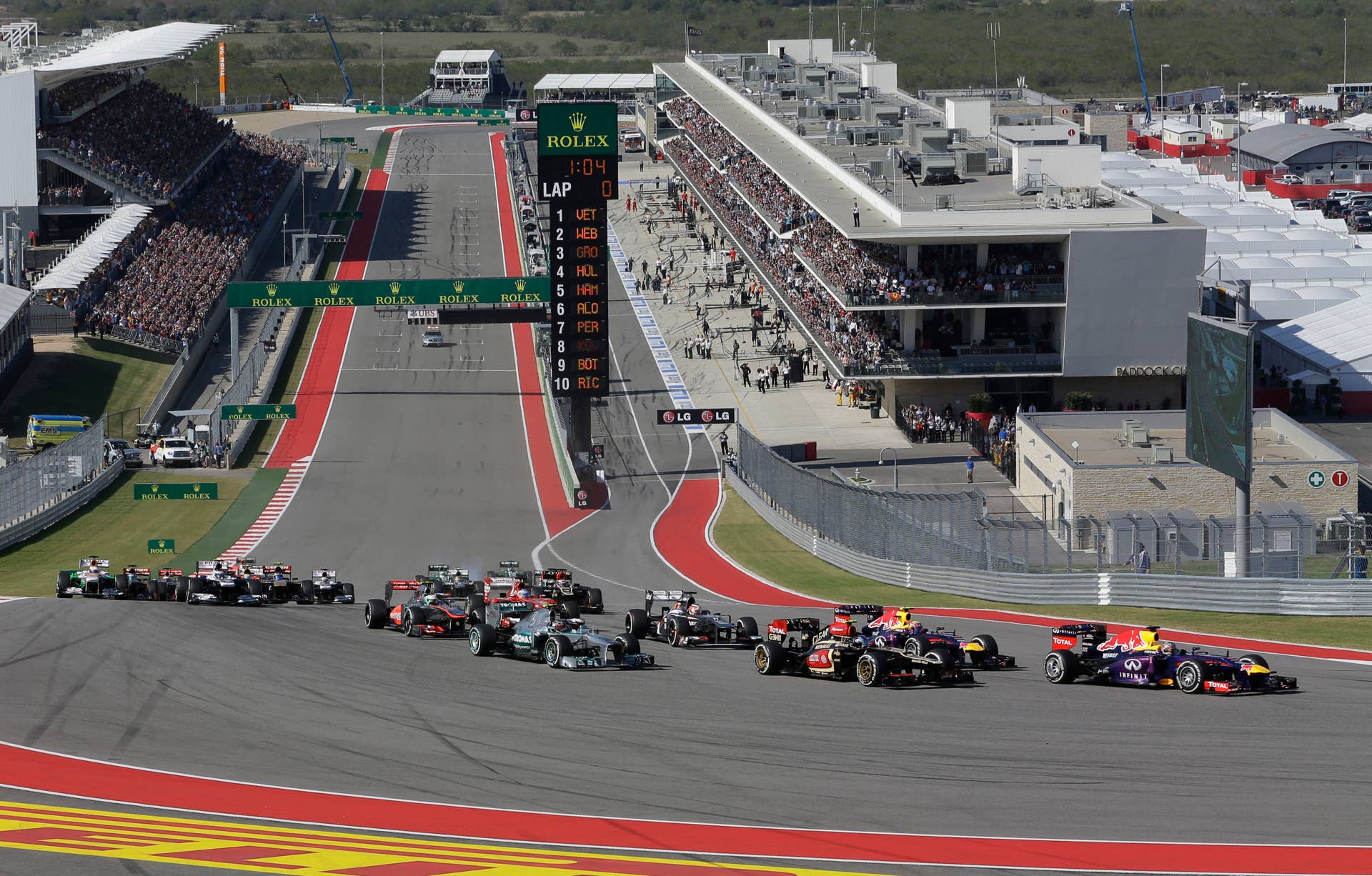 Lotus driver Romain Grosjean of Switzerland, second right, pulls into second place next to Red Bull driver Mark Webber of Australia as Red Bull driver Sebastian Vettel of Germany leads the start of the Formula One U.S. Grand Prix auto race at the Circuit of the Americas, Sunday, Nov. 17, 2013, in Austin, Texas. (AP Photo/Eric Gay)