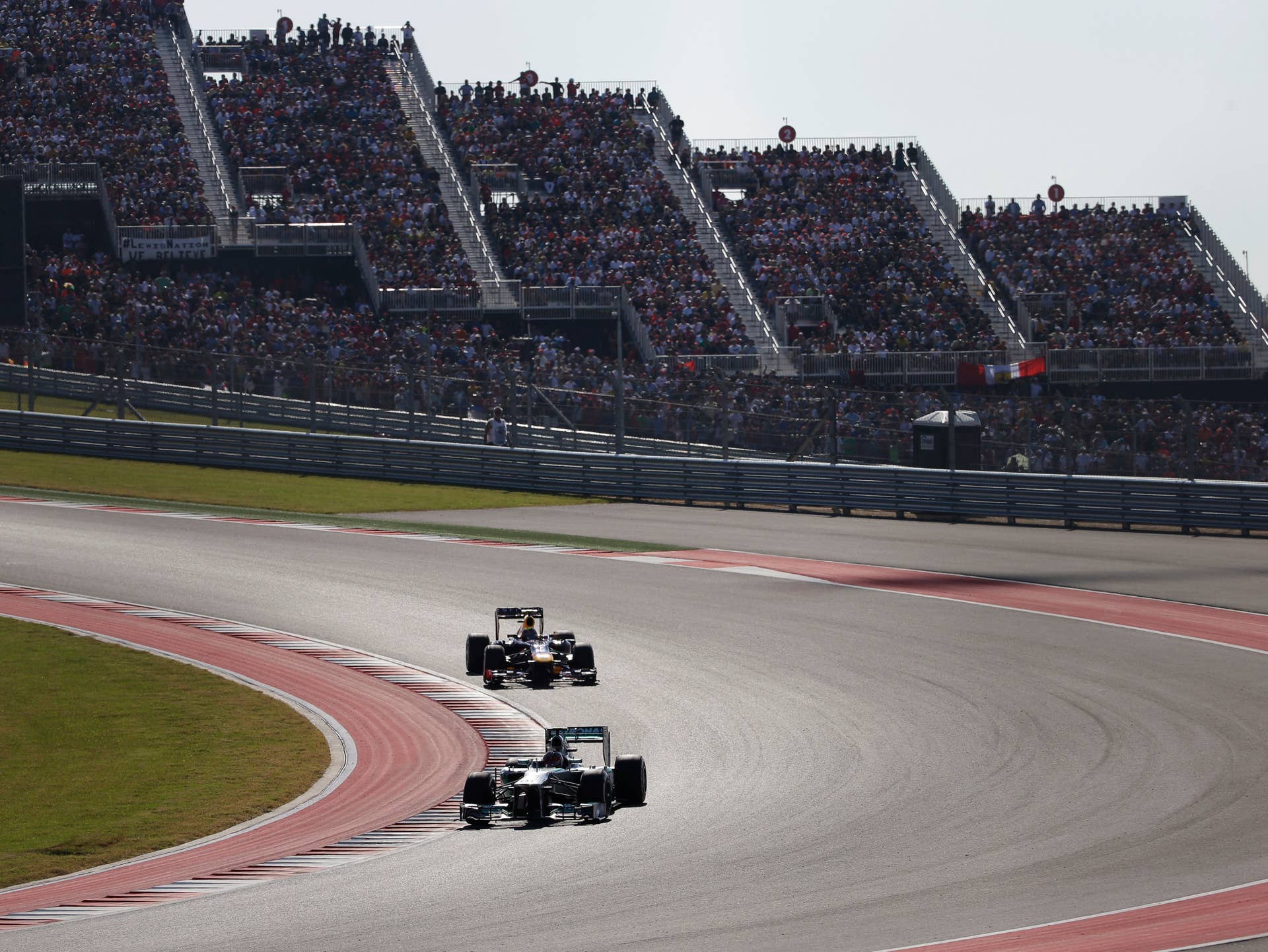 Mercedes driver Lewis Hamilton of Britain leads Red Bull driver Mark Webber of Australia during the Formula One U.S. Grand Prix auto race at the Circuit of the Americas, Sunday, Nov. 17, 2013, in Austin, Texas. (AP Photo/David J. Phillip)