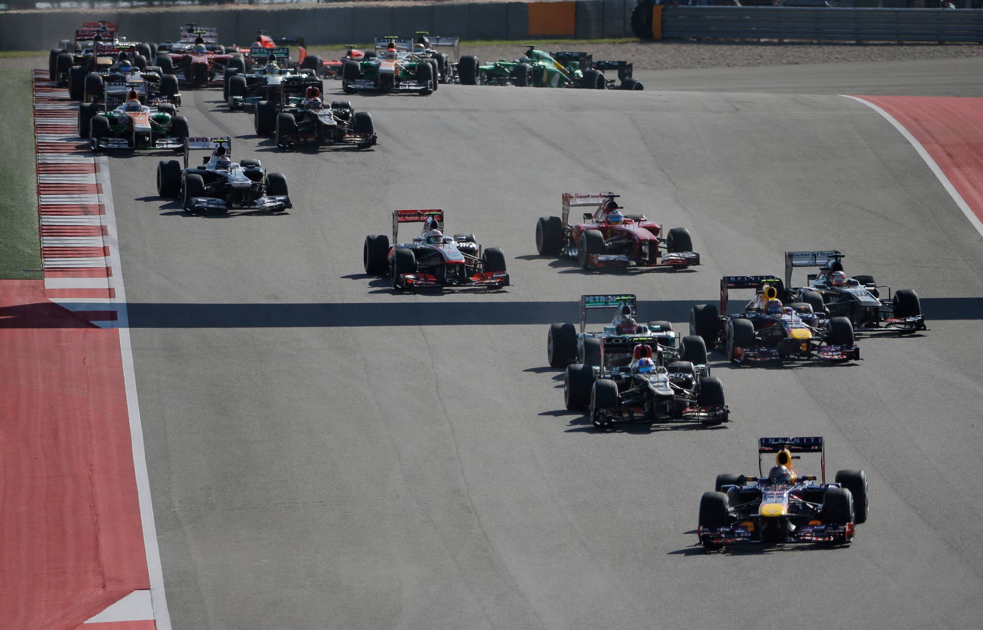 Red Bull driver Sebastian Vettel of Germany leads the field as the make the first turn at the start of the Formula One U.S. Grand Prix auto race at the Circuit of the Americas, Sunday, Nov. 17, 2013, in Austin, Texas. (AP Photo/David J. Phillip)