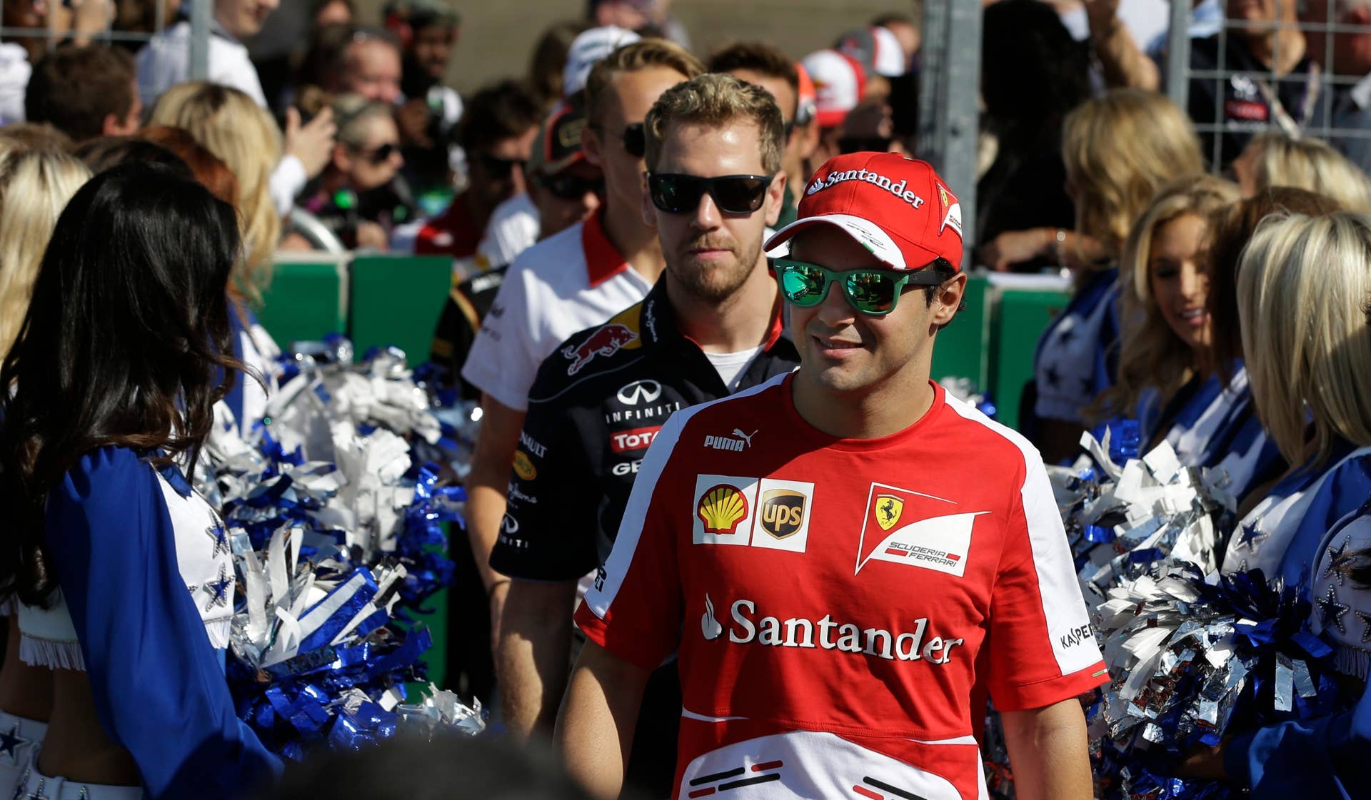 Ferrari driver Felipe Massa of Brazil walks ahead of Red Bull driver Sebastian Vettel of Germany as they make their way past the Dallas Cowboys cheerleaders before the Formula One U.S. Grand Prix auto race at the Circuit of the Americas, Sunday, Nov. 17, 2013, in Austin, Texas. (AP Photo/Darron Cummings)