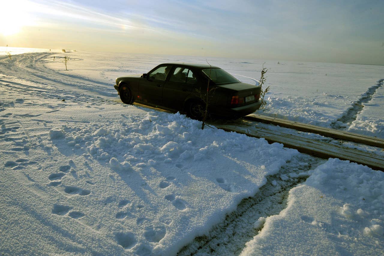 A car drives on February 17, 2011 on a wooden crossing built to pass cracks in the ice on Estonia's longest ice road in Europe. The 26.5 kms road in western Estonia, which links the mainland to the country's second largest island of Hiiumaa, is to open on February 18 when the ice is thick enough. AFP PHOTO / RAIGO PAJULA