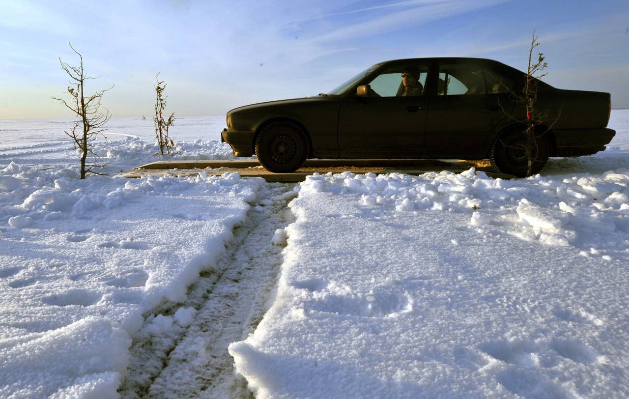 A car drives on February 17, 2011 on a wooden crossing built to pass cracks in the ice on Estonia's longest ice road in Europe. The 26.5 kms road in western Estonia, which links the mainland to the country's second largest island of Hiiumaa, is to open on February 18 when the ice is thick enough. AFP PHOTO / RAIGO PAJULA