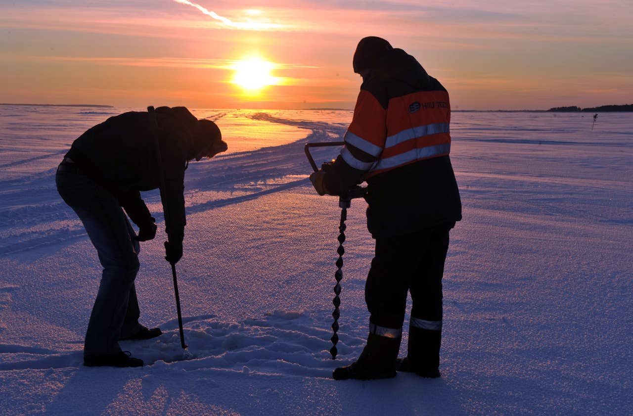 Workers measure on February 17, 2011 the thickness of the ice, which was between 30 and 40 centimeter, along Estonia's longest ice road in Europe. The 26.5 kms road in western Estonia, which links the mainland to the country's second largest island of Hiiumaa, is to open on February 18 when the ice is thick enough. AFP PHOTO / RAIGO PAJULA