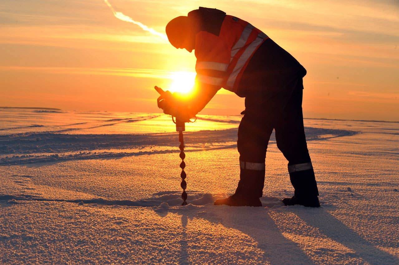 A worker measures on February 17, 2011 the thickness of the ice, which was between 30 and 40 centimeter, along Estonia's longest ice road in Europe. The 26.5 kms road in western Estonia, which links the mainland to the country's second largest island of Hiiumaa, is to open on February 18 when the ice is thick enough. AFP PHOTO / RAIGO PAJULA
