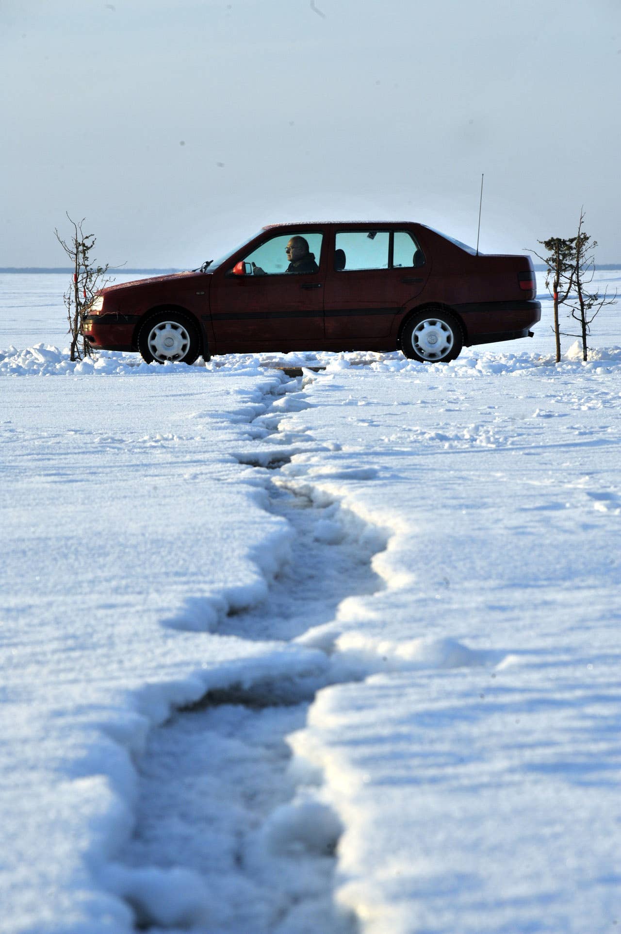 A car drives on February 17, 2011 on a wooden crossing built to pass cracks in the ice on Estonia's longest ice road in Europe. The 26.5 kms road in western Estonia, which links the mainland to the country's second largest island of Hiiumaa, is to open on February 18 when the ice is thick enough. AFP PHOTO / RAIGO PAJULA