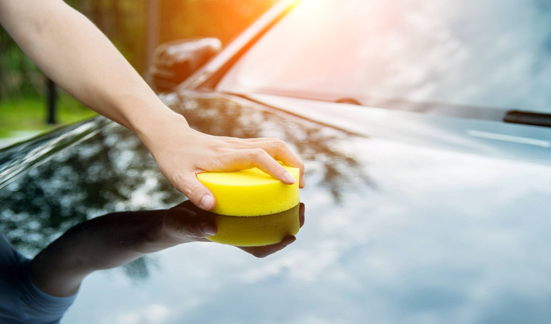 Woman hand polishing her black car.