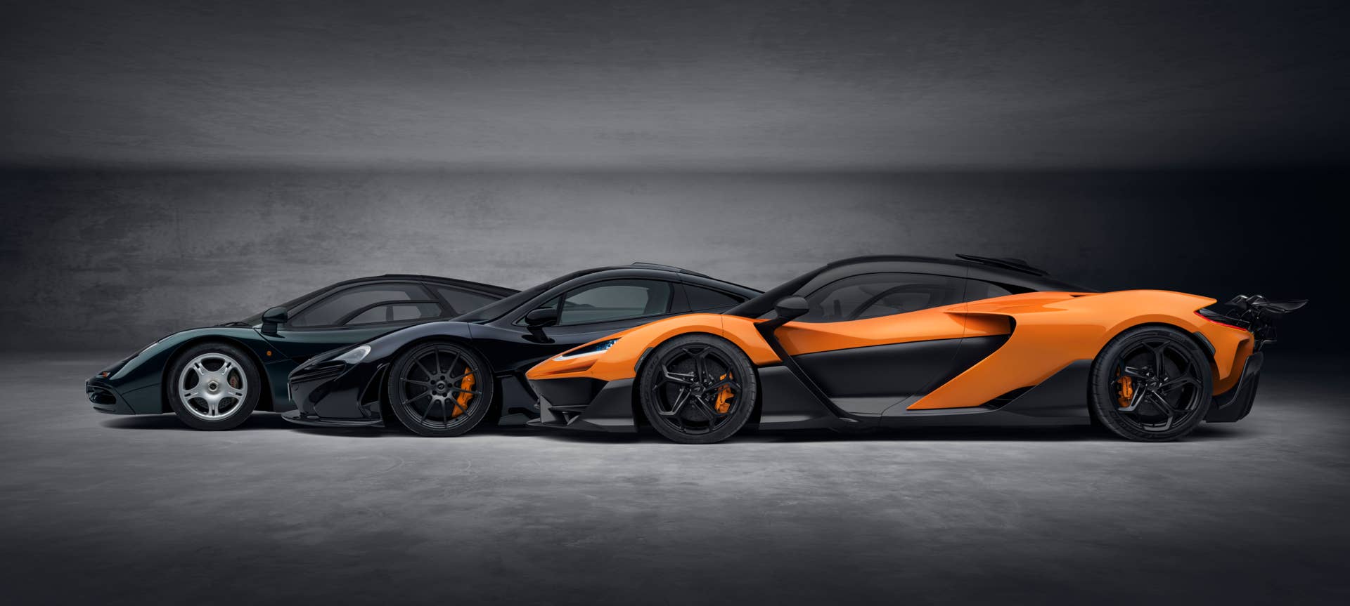 Sideview of three overlapping McLaren W1s in green, black, and orange