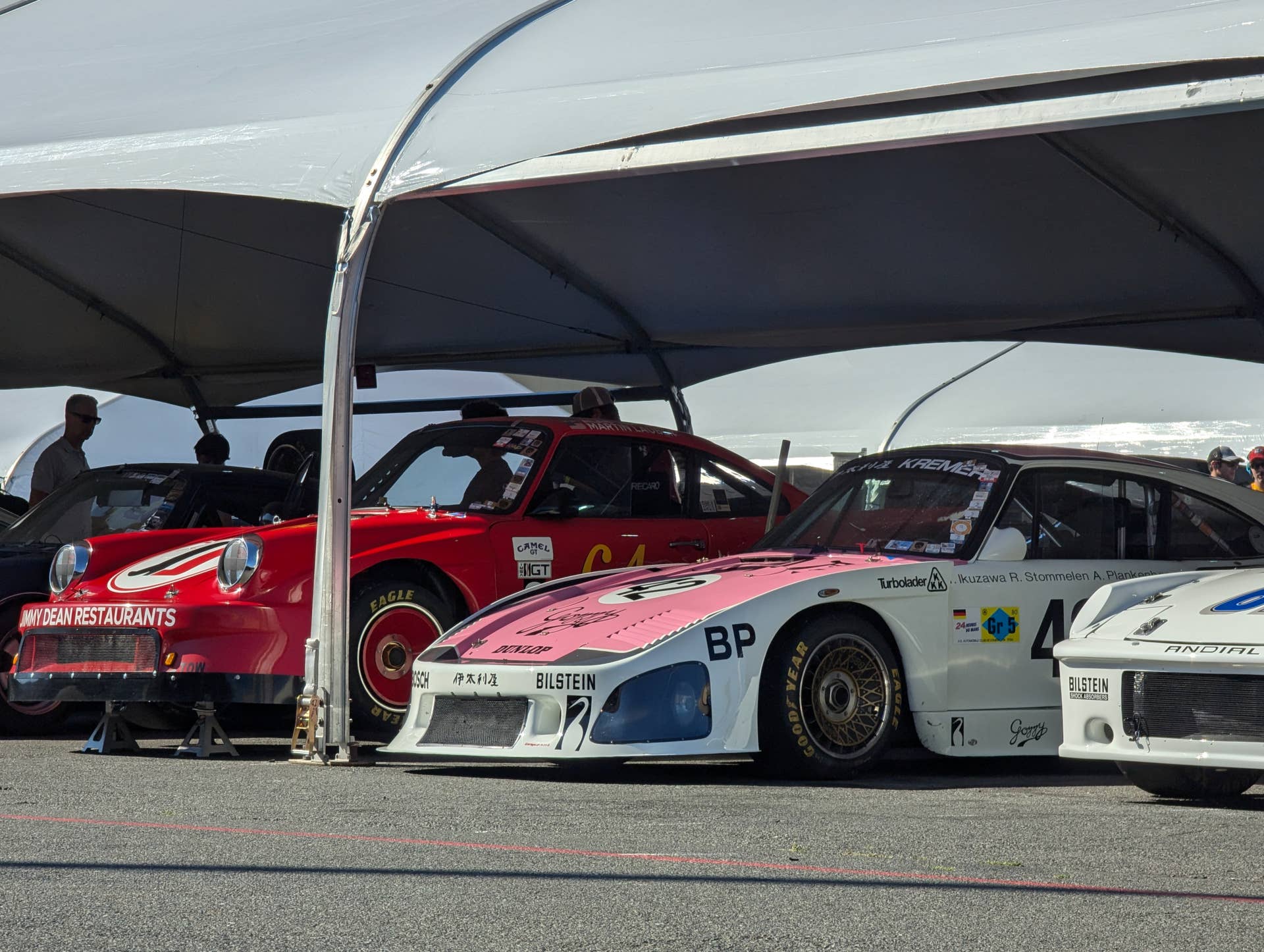 An assortment of racing Porsches in the Sonoma Raceway paddocks