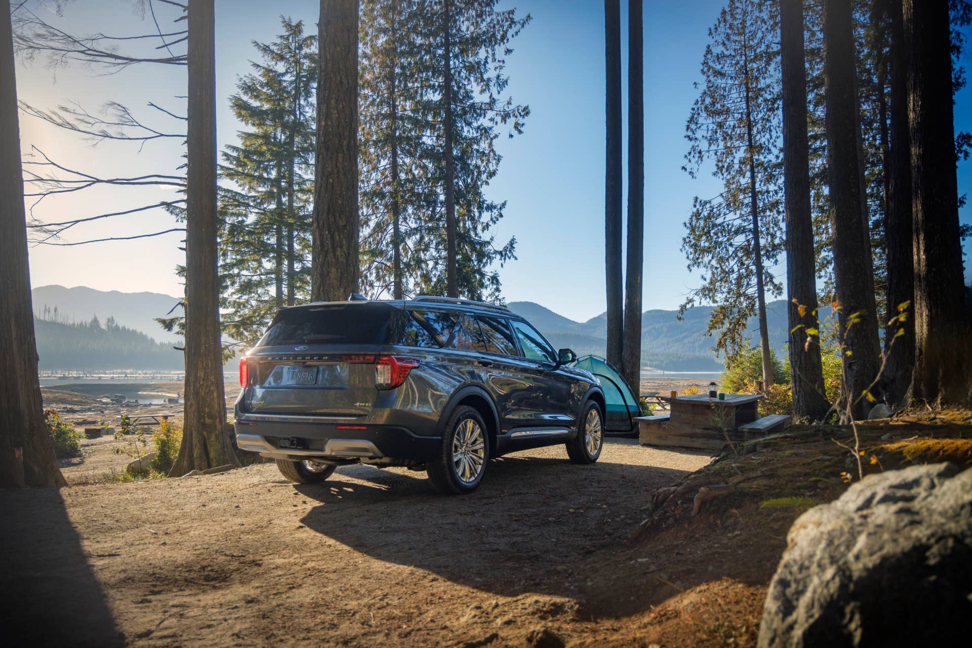Rear view of a 2025 Ford Explorer ST parked at a camp in the woods