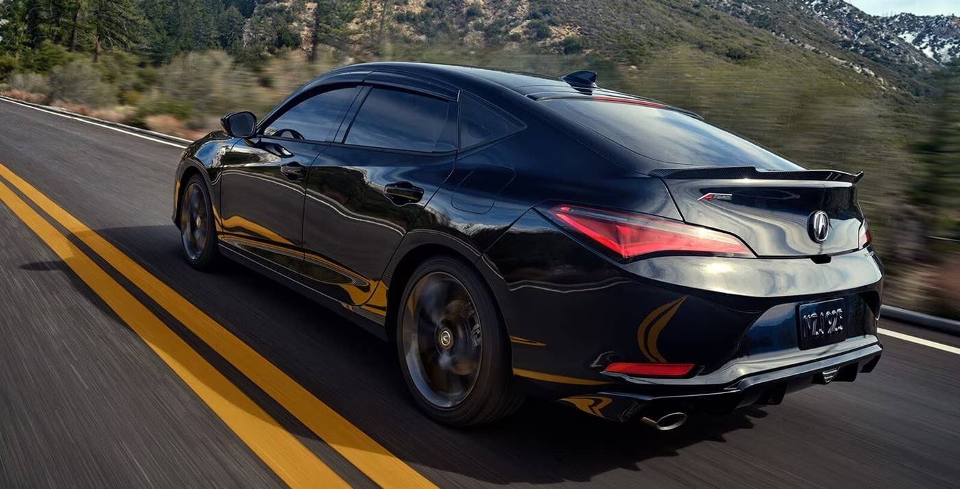 Rear 3/4 view of a 2025 Acura Integra driving