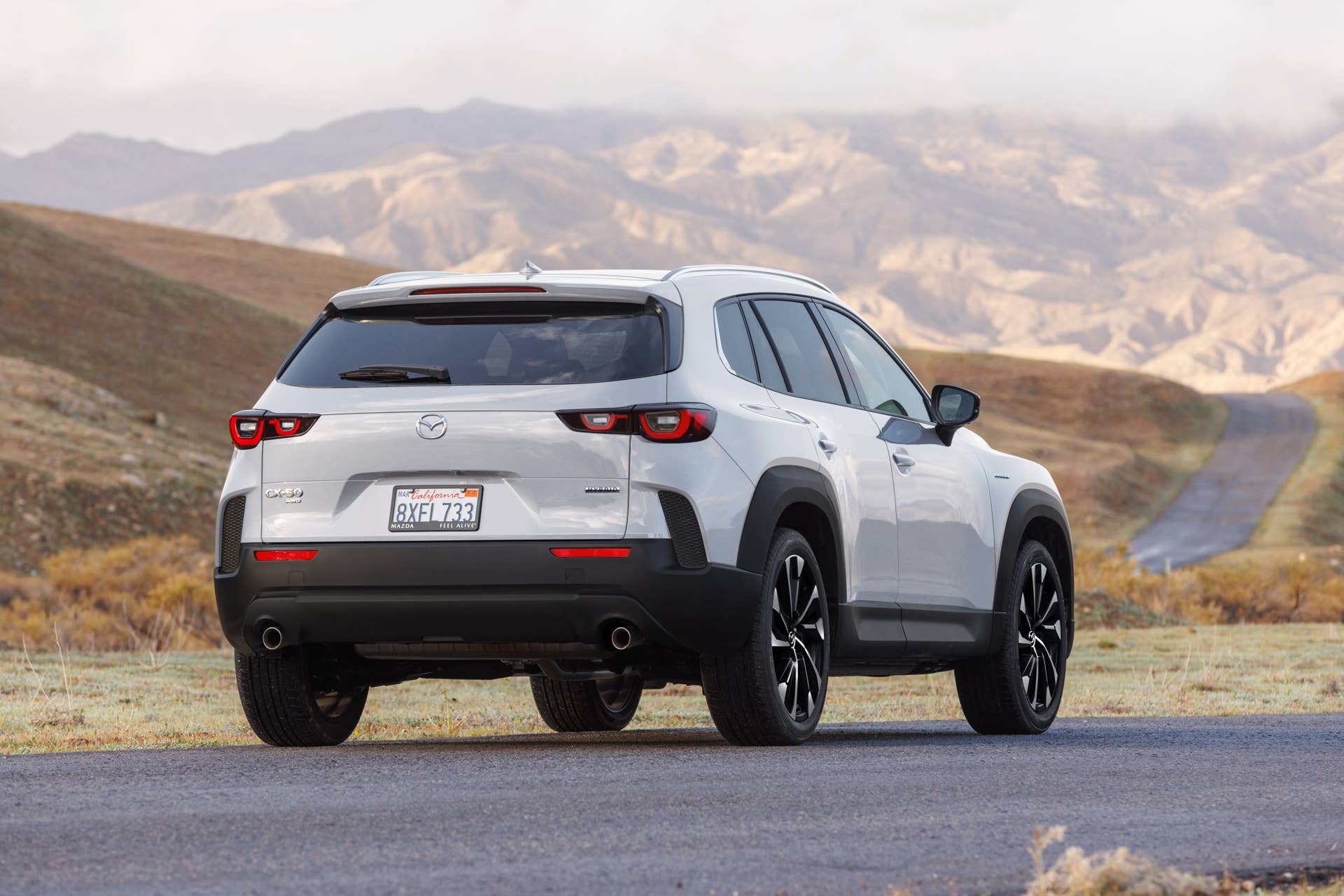 Rear shot of the Mazda CX-50 Hybrid facing some mountains