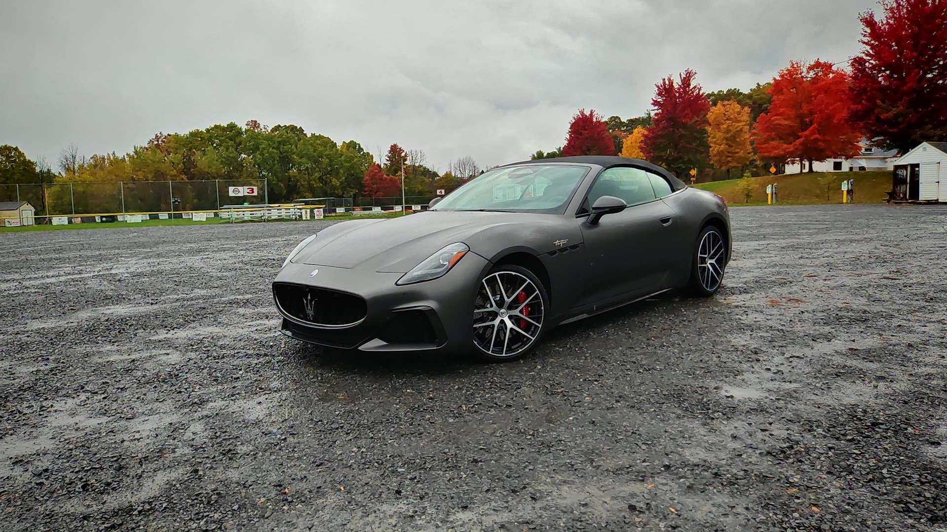 Maserati GranCabrio Trofeo in a wet gravel parking lot