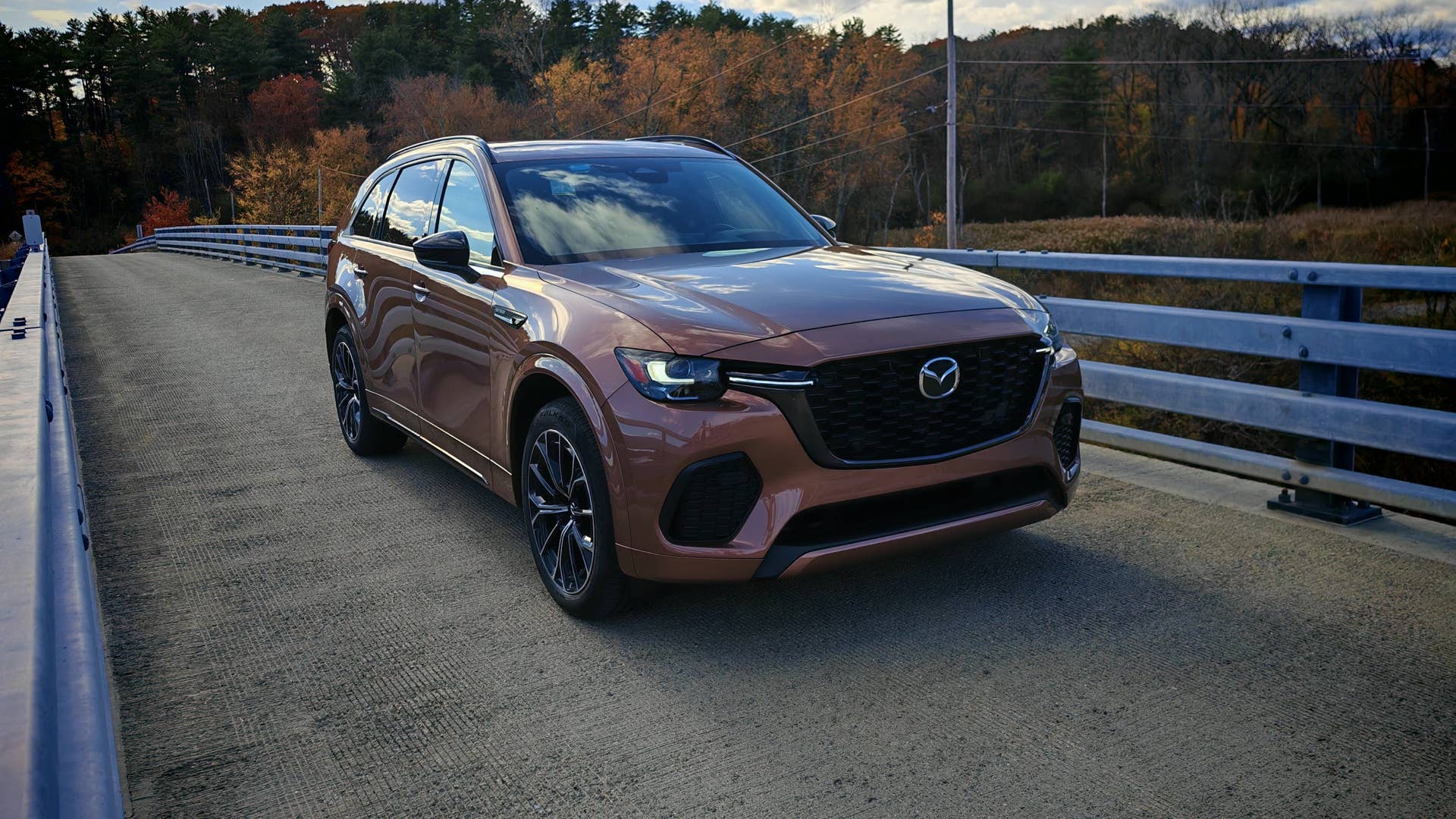 Front 3/4 view of a copper colored Mazda CX-70 on a bridge