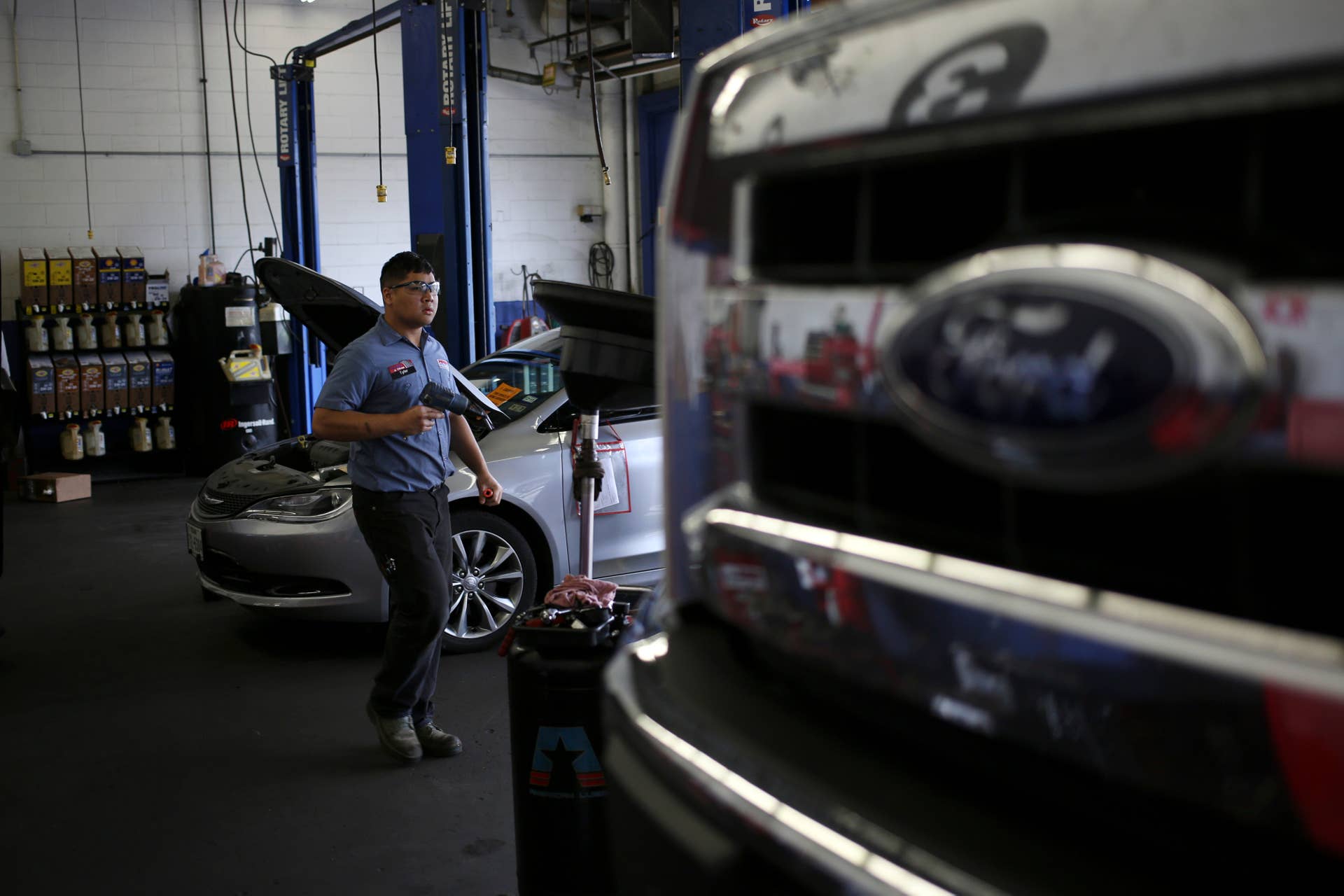 A mechanic prepares to do a tire rotation during an oil change at a Pep Boys in Clarksville, Indiana