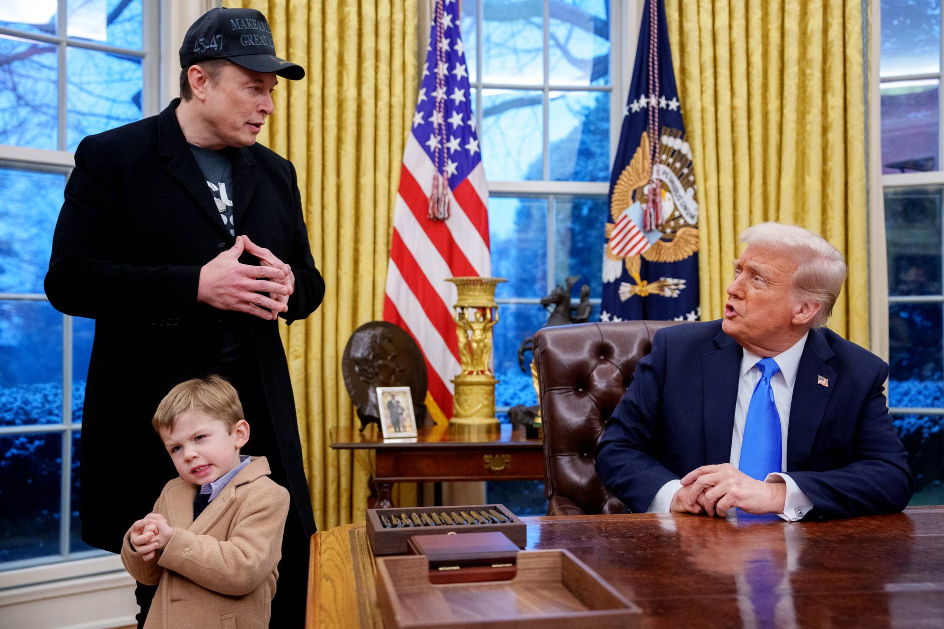 WASHINGTON, DC - FEBRUARY 11: U.S. President Donald Trump is joined by Tesla and SpaceX CEO Elon Musk, and his son, X Musk, during an executive order signing in the Oval Office at the White House on February 11, 2025 in Washington, DC. Trump is to sign an executive order implementing the Department of Government Efficiency's (DOGE) "workforce optimization initiative," which, according to Trump, will encourage agencies to limit hiring and reduce the size of the federal government. (Photo by Andrew Harnik/Getty Images)